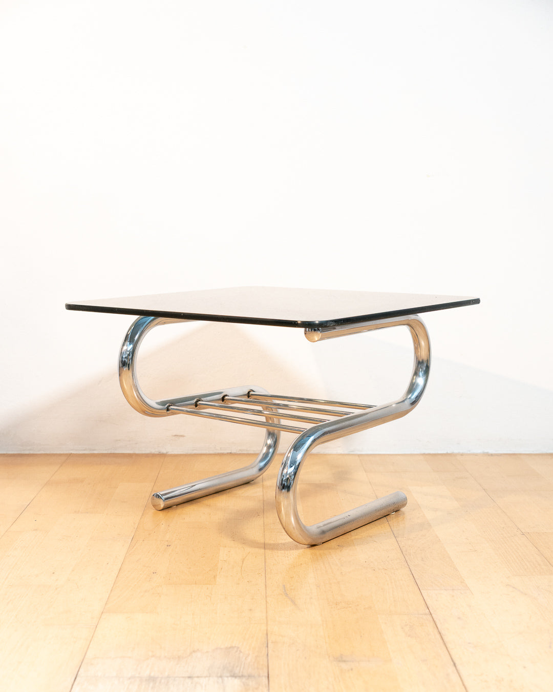 Sculptural 1970s vintage side table with smoked glass top and tubular chrome S-shaped frame with rack. Mid-century design in very good condition.
