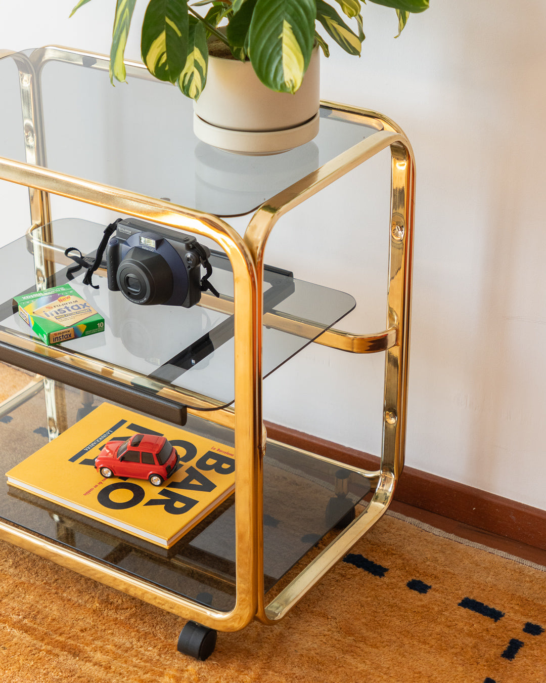 Vintage 1970s gold and smoked glass 3-tier side table, middle sliding shelf, wheels, polished and restored, very good condition | Vecino Shop