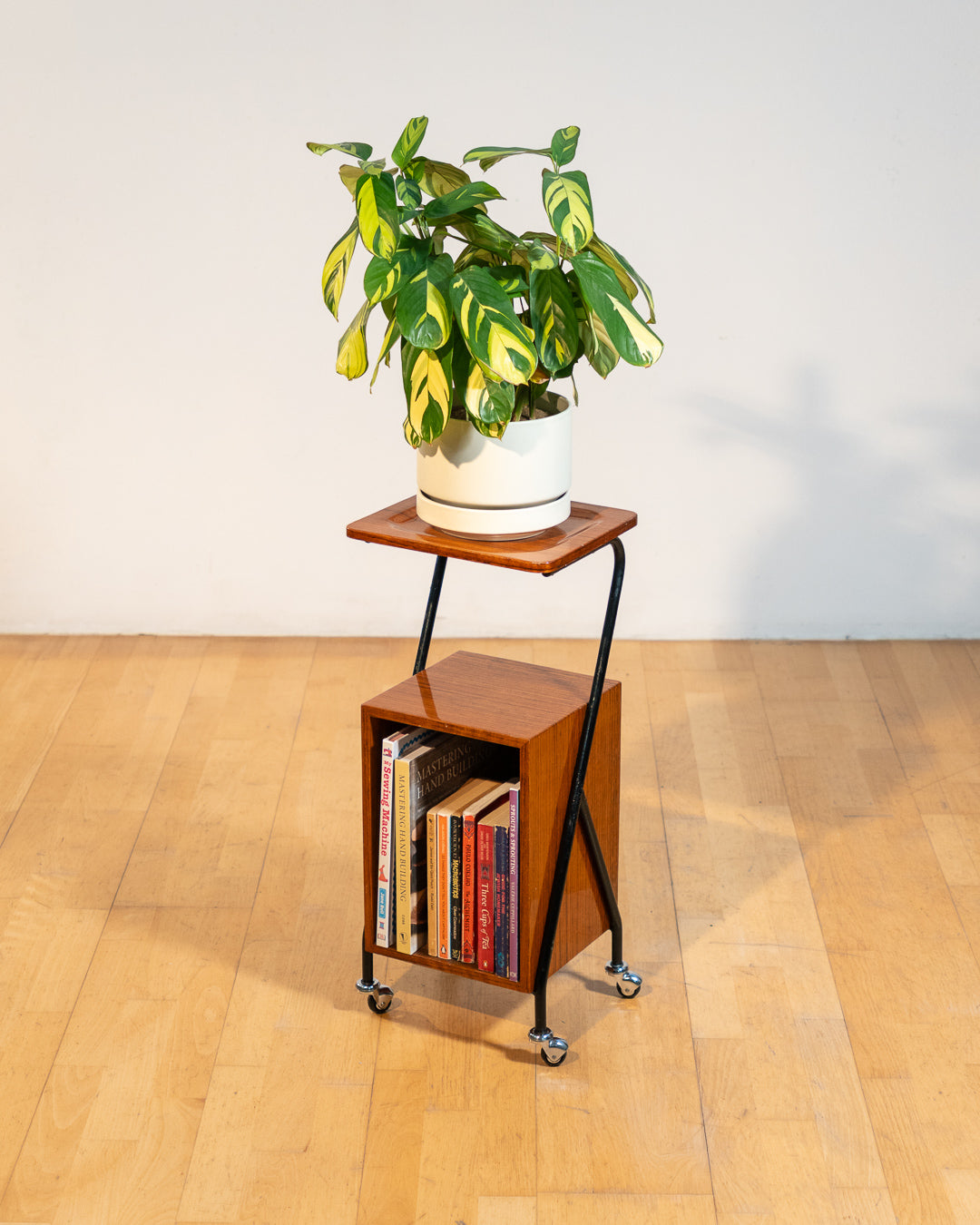 1960s mid-century rolling side table, wood veneer top, chrome frame, built-in bookcase. Vecino Shop