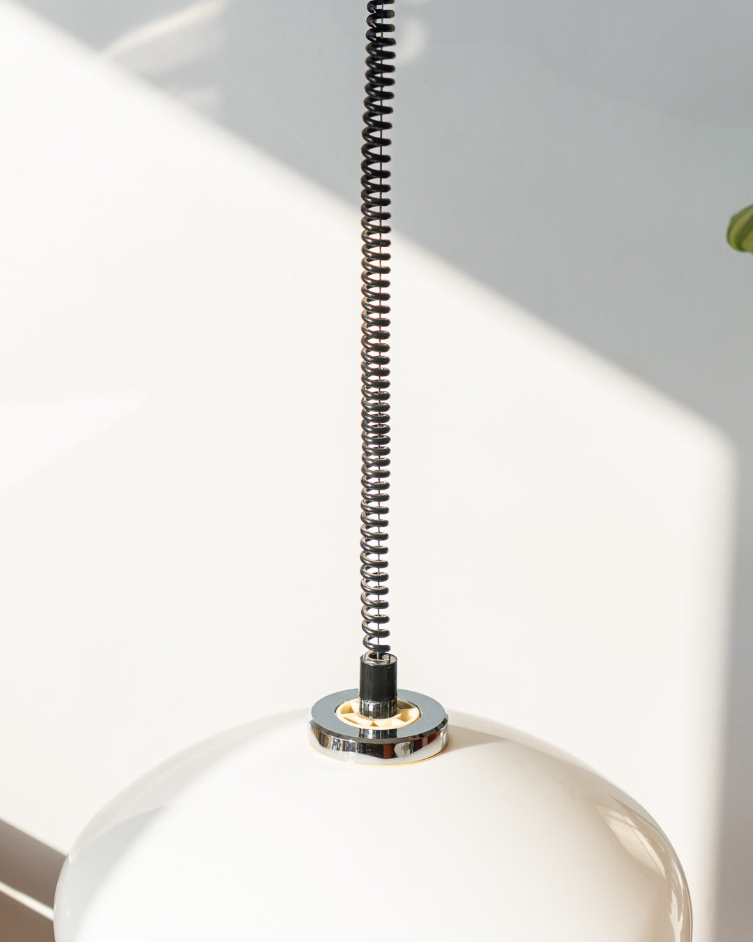 Retro 1960s/70s extendable Space Age ceiling lamp with white plastic shade, chrome accents, and black spiral cord. Sculptural, functional, and iconic.
