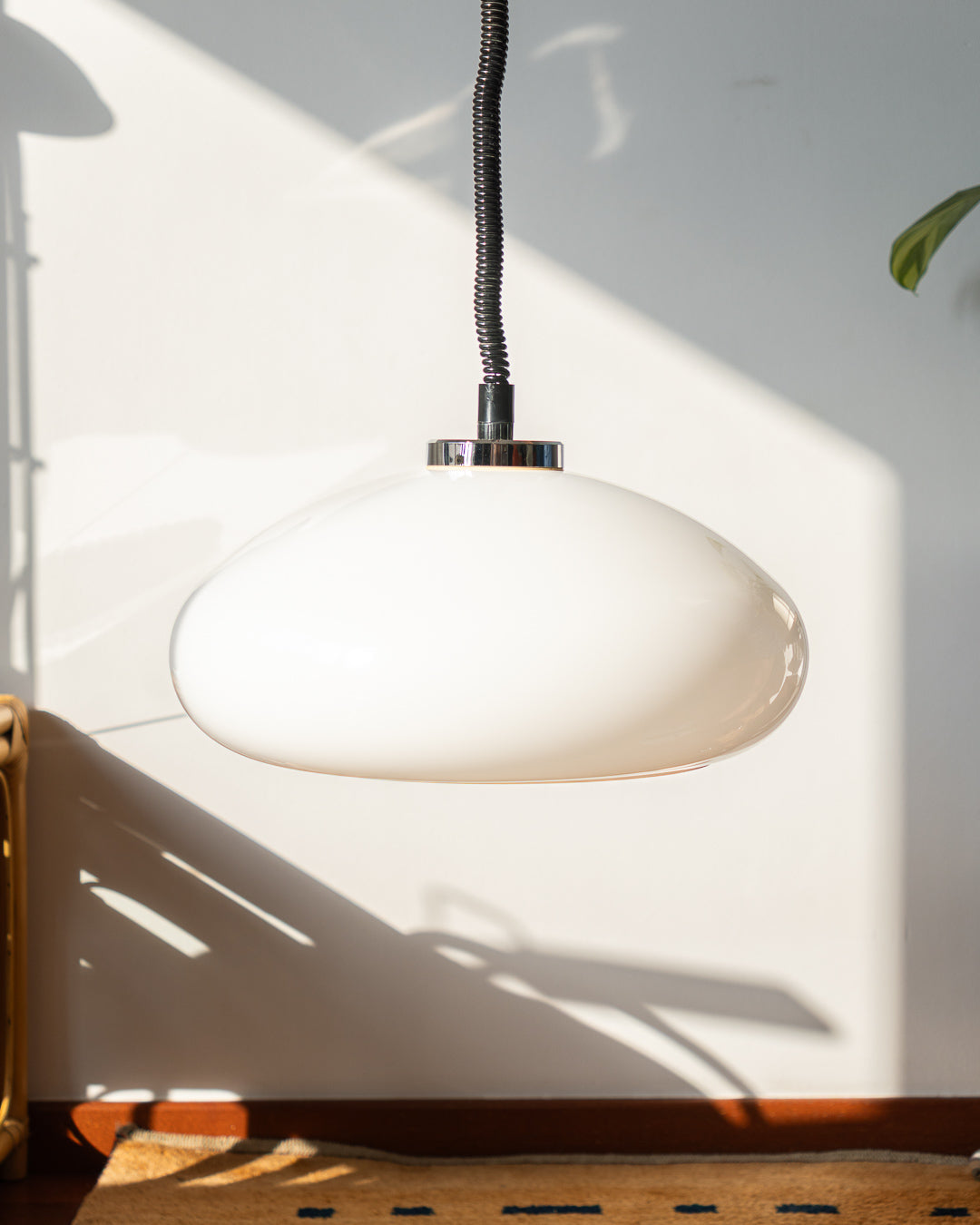 Retro 1960s/70s extendable Space Age ceiling lamp with white plastic shade, chrome accents, and black spiral cord. Sculptural, functional, and iconic.