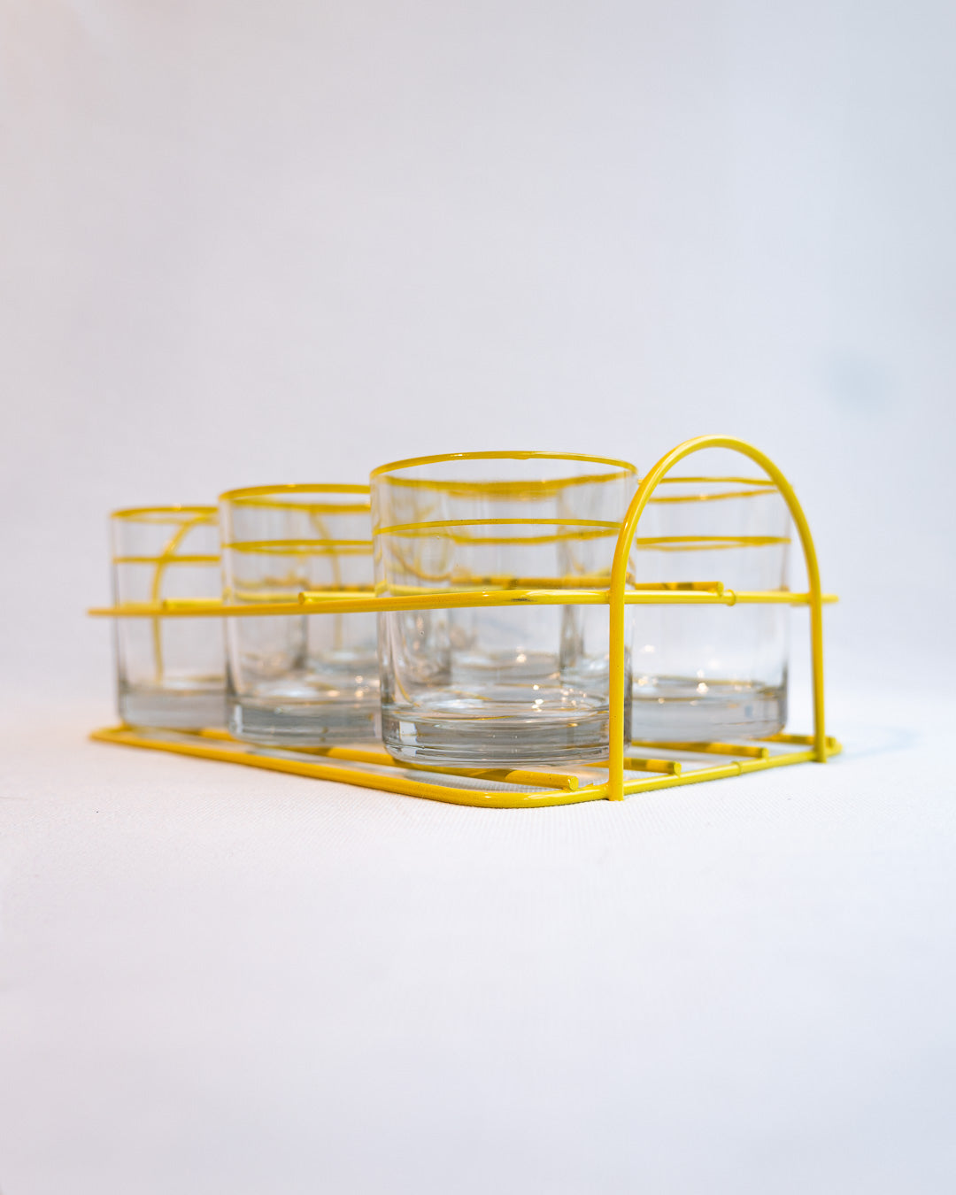 Set of six vintage clear glasses with yellow stripes in a yellow metal serving rack, retro drinkware display - Vecino Shop