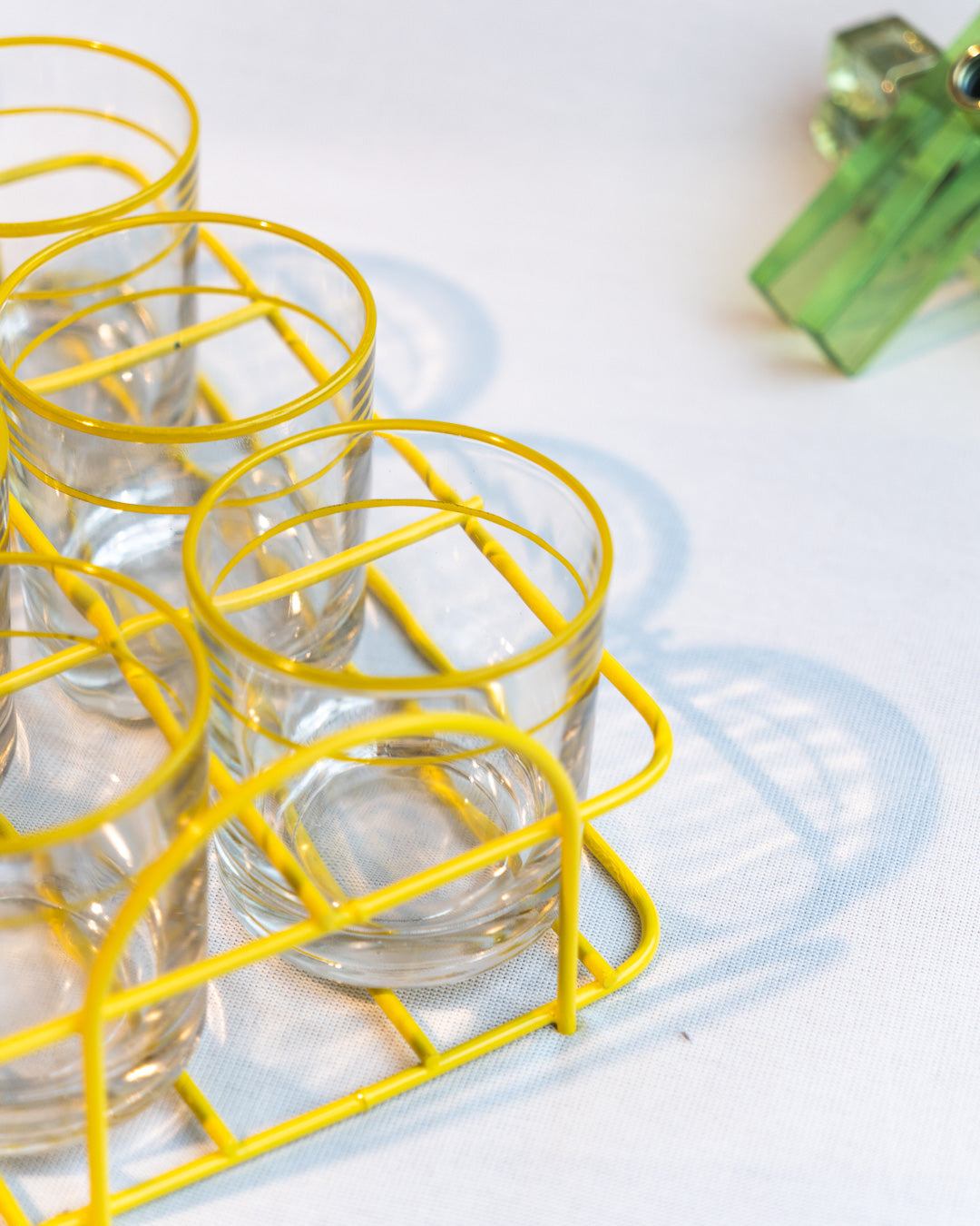 Set of six vintage clear glasses with yellow stripes in a yellow metal serving rack, retro drinkware display - Vecino Shop