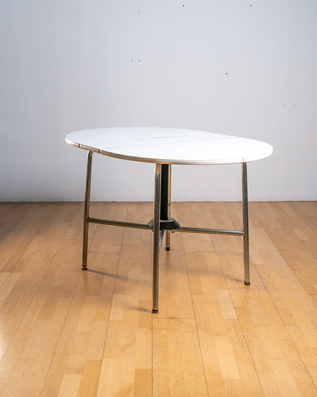 Vintage 1970s round folding dining table with chrome tubular legs and white Formica top. Space-saving design with three positions. Vecino Shop