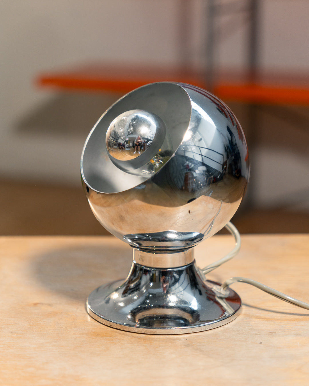 Vintage chrome eyeball table lamp from the 1970s with spherical shade and chrome-dipped bulb. Vecino Shop