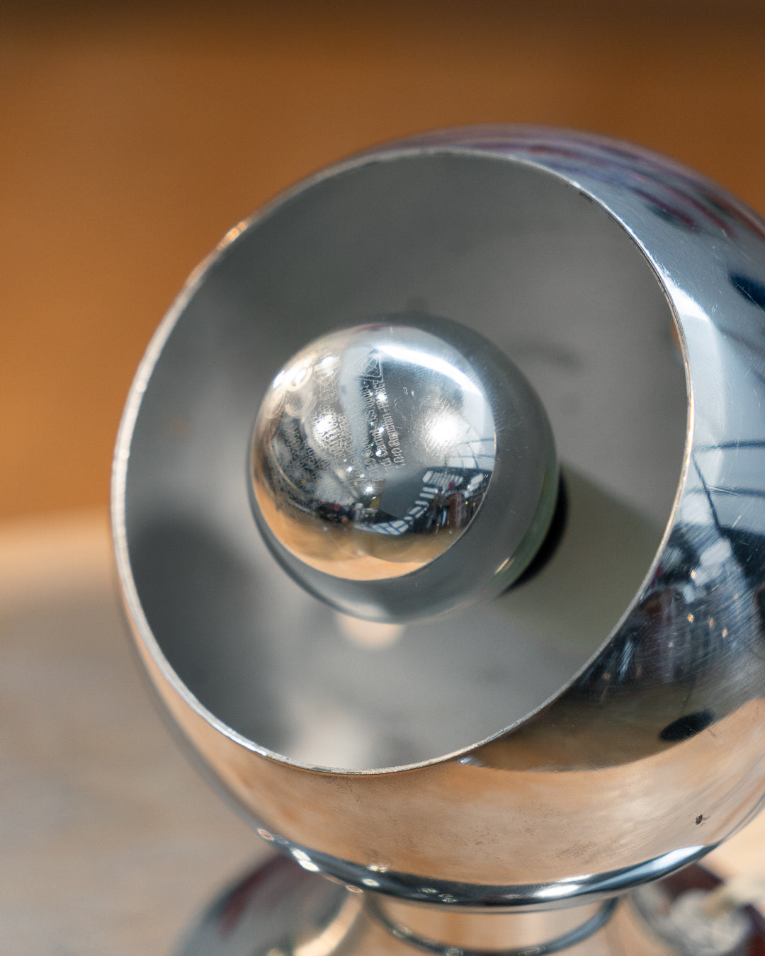 Vintage chrome eyeball table lamp from the 1970s with spherical shade and chrome-dipped bulb. Vecino Shop
