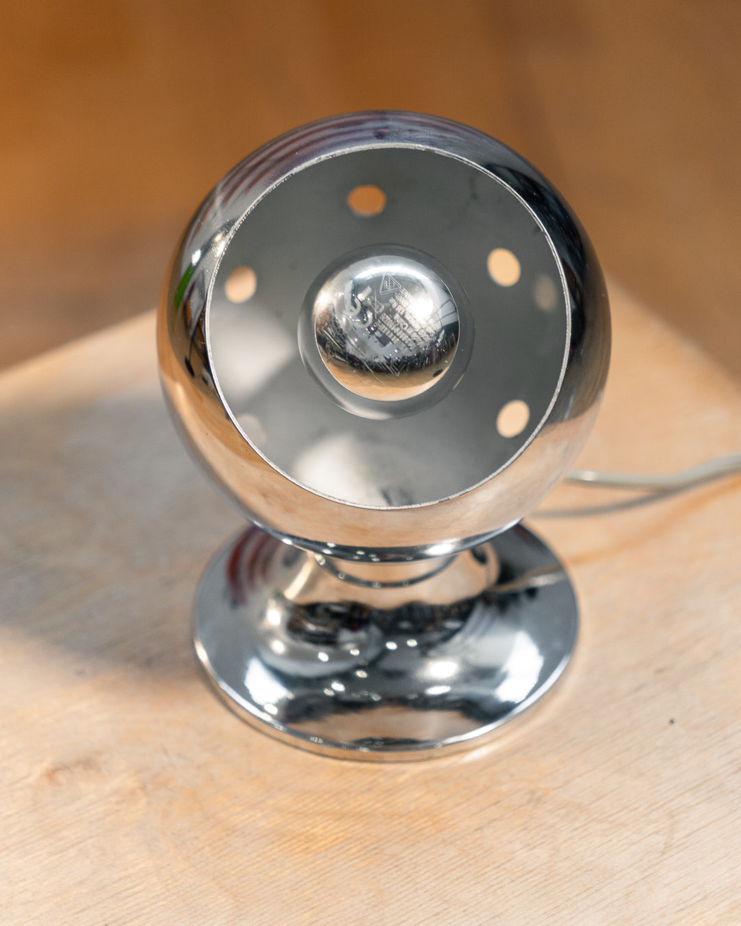 Vintage chrome eyeball table lamp from the 1970s with spherical shade and chrome-dipped bulb. Vecino Shop