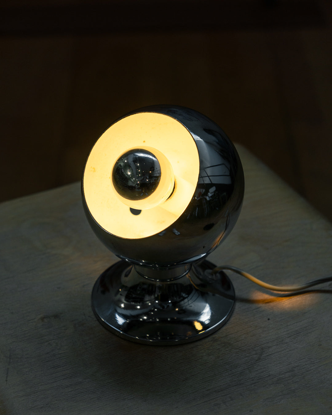 Vintage chrome eyeball table lamp from the 1970s with spherical shade and chrome-dipped bulb. Vecino Shop