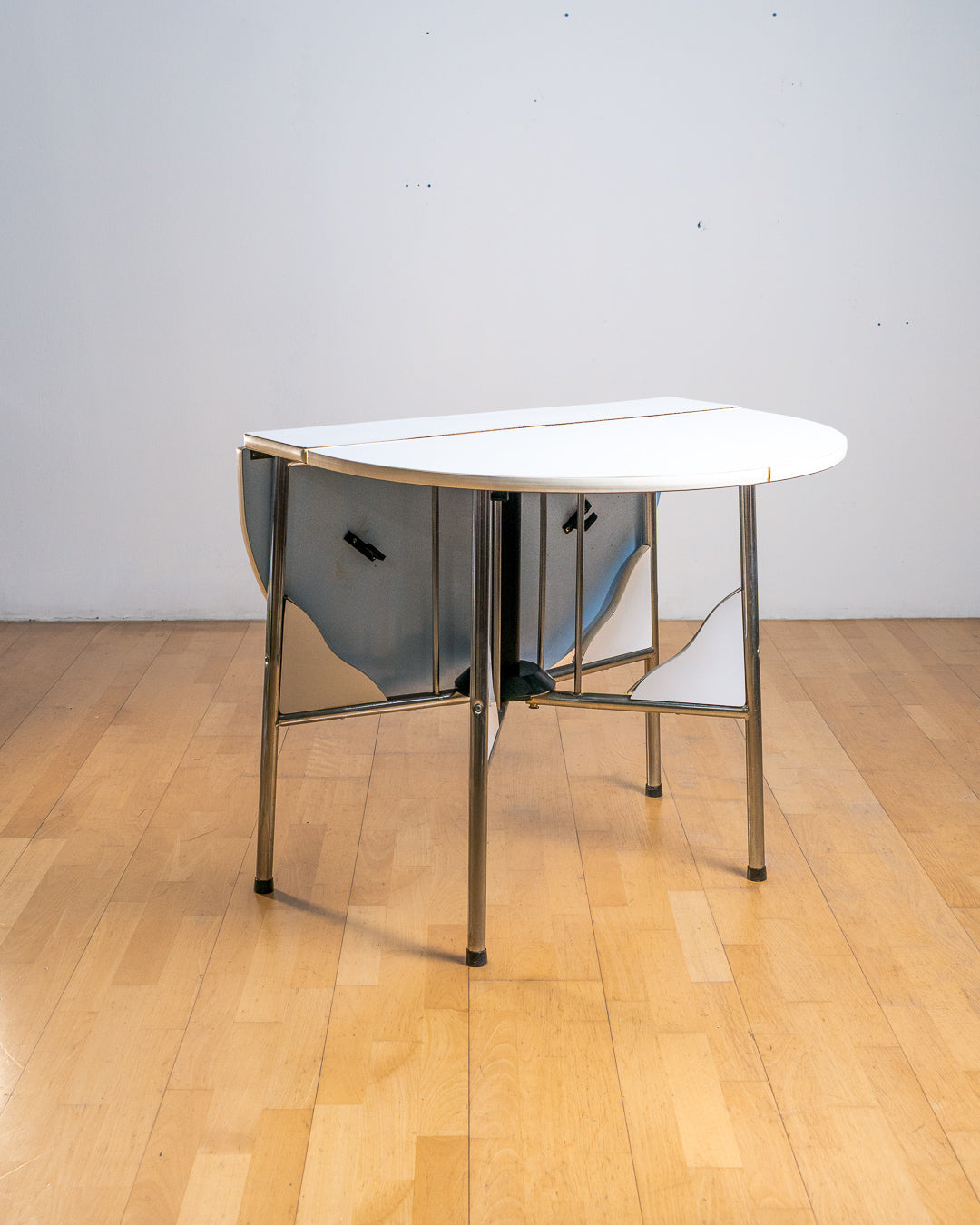 Vintage 1980s folding dining table with chrome tubular legs and a custom made Formica tabletop. Paneled leg inserts and a functional Space Age design. Vecino Shop