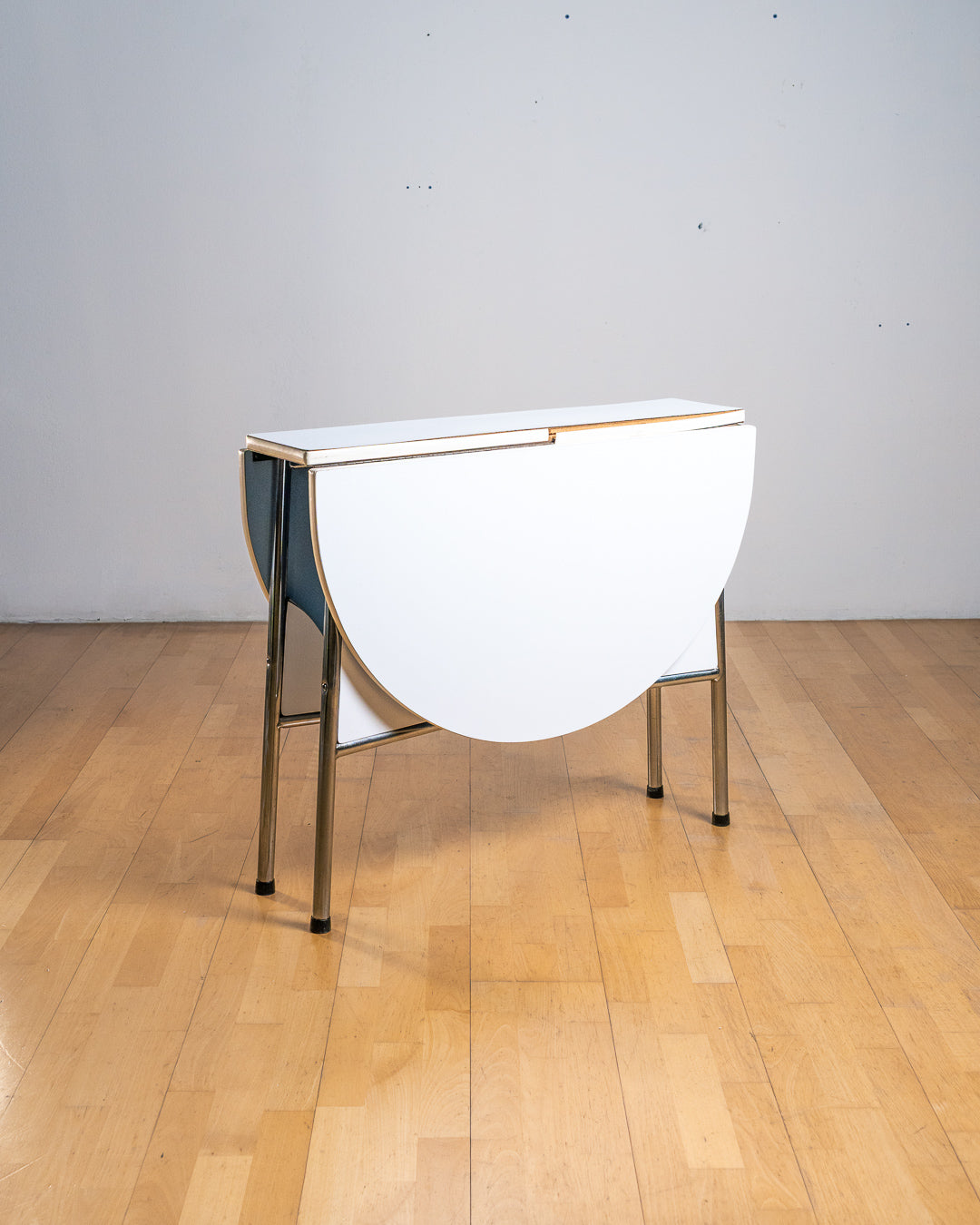Vintage 1980s folding dining table with chrome tubular legs and a custom made Formica tabletop. Paneled leg inserts and a functional Space Age design. Vecino Shop