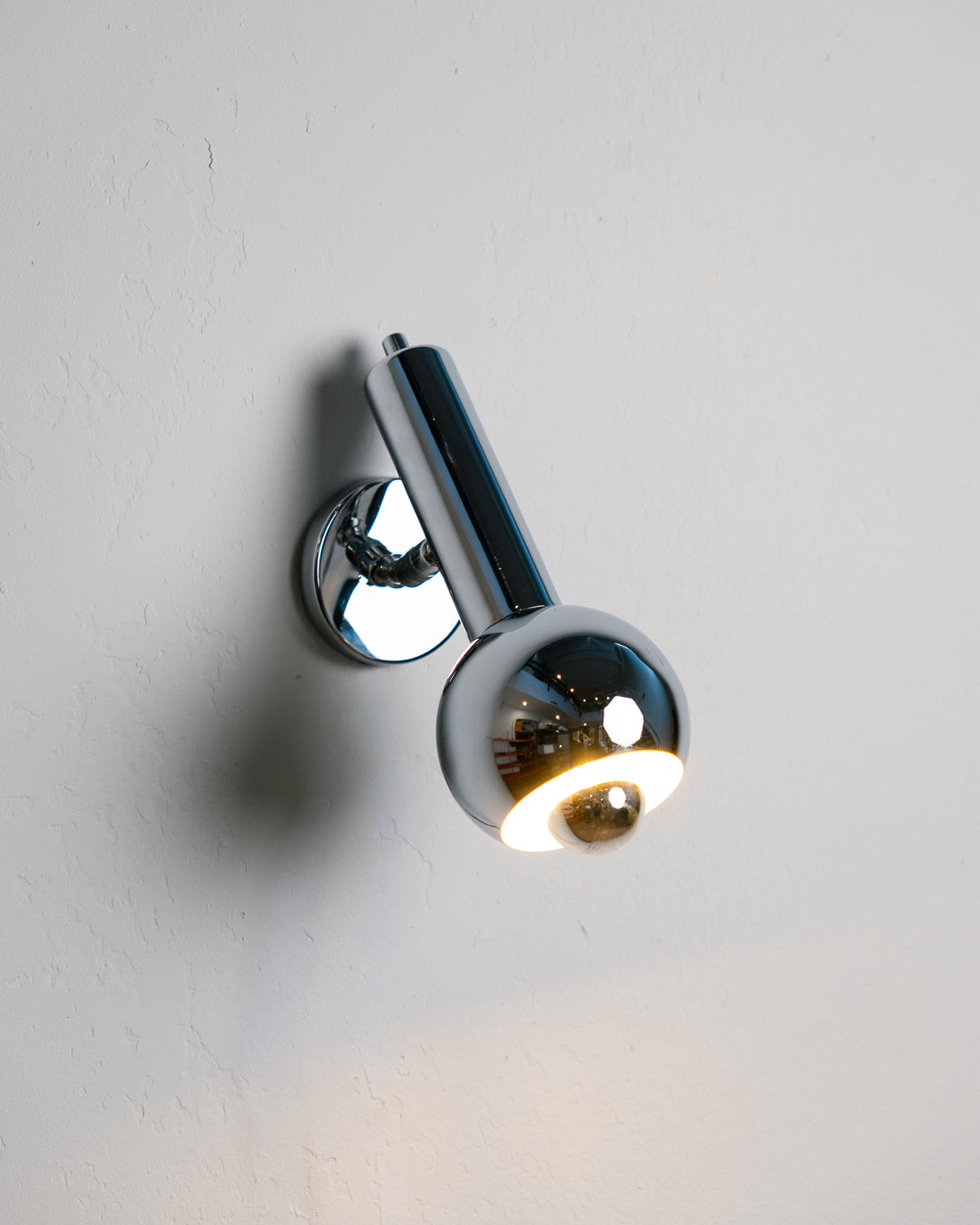 Vintage 1970s chrome adjustable eyeball spotlight wall sconce with chrome-tipped bulb. Mid Century, Space Age lighting.  Vecino Shop