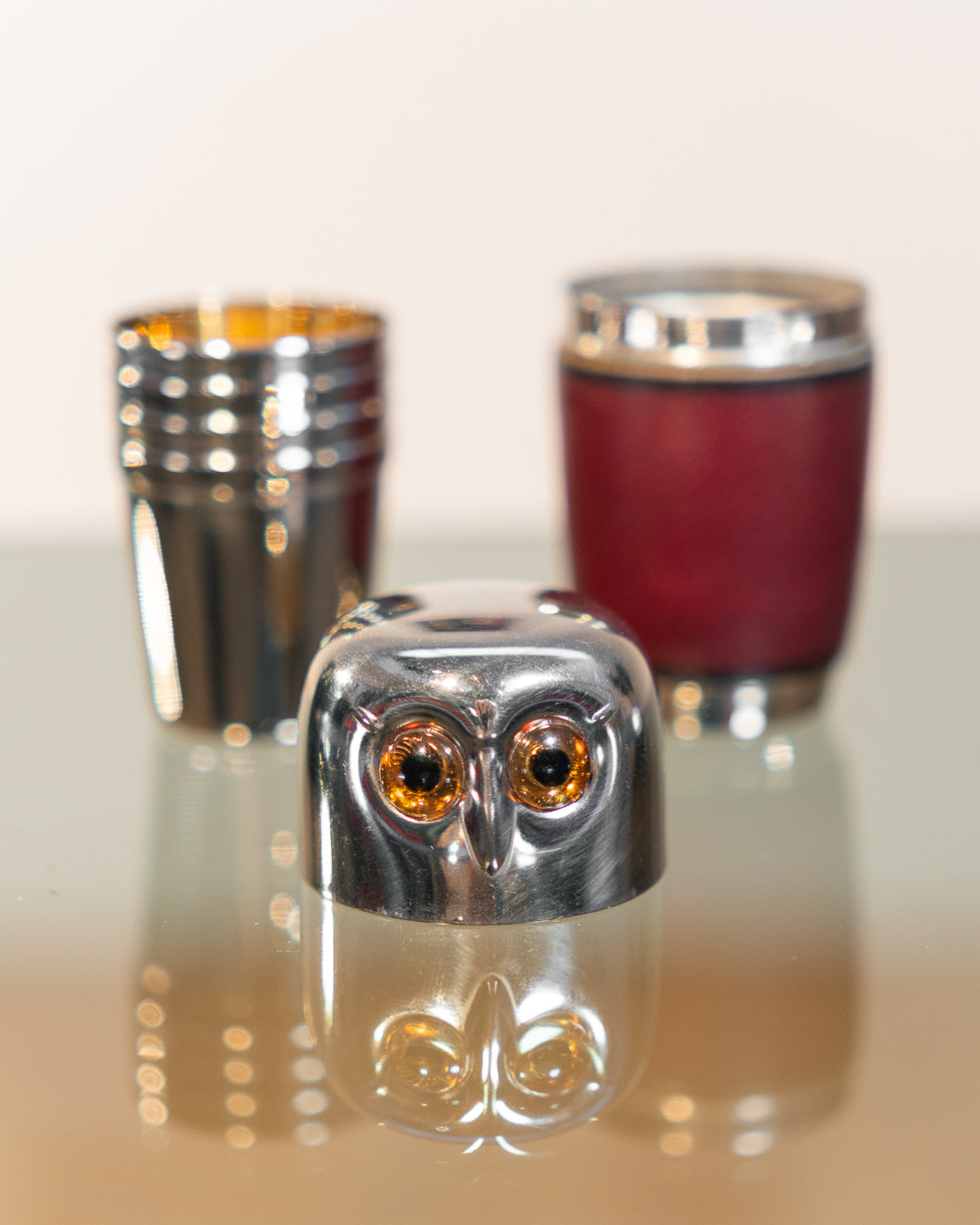Vintage owl nesting shot glass set from West Germany with chrome head, amber eyes, and leather body. Vecino Shop