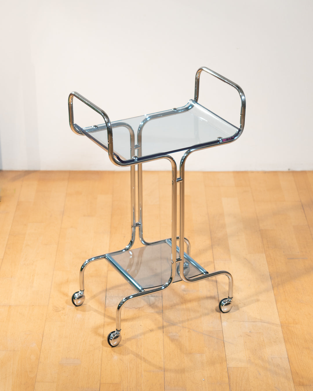 1970s chrome rolling side table with baby blue acrylic shelves, two-level mid-century modern design. Vecino Shop