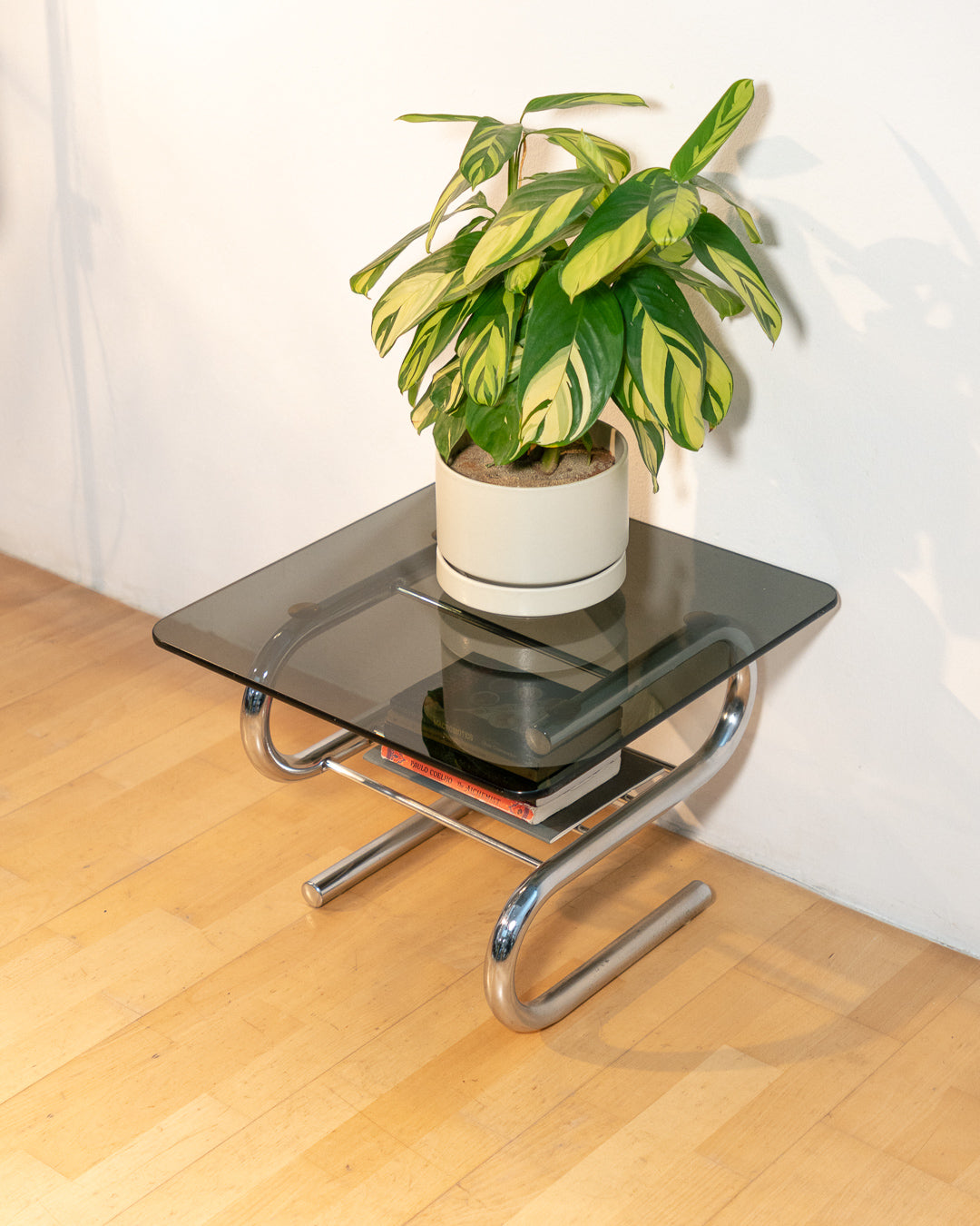 Sculptural 1970s vintage side table with smoked glass top and tubular chrome S-shaped frame with rack. Mid-century design in very good condition.