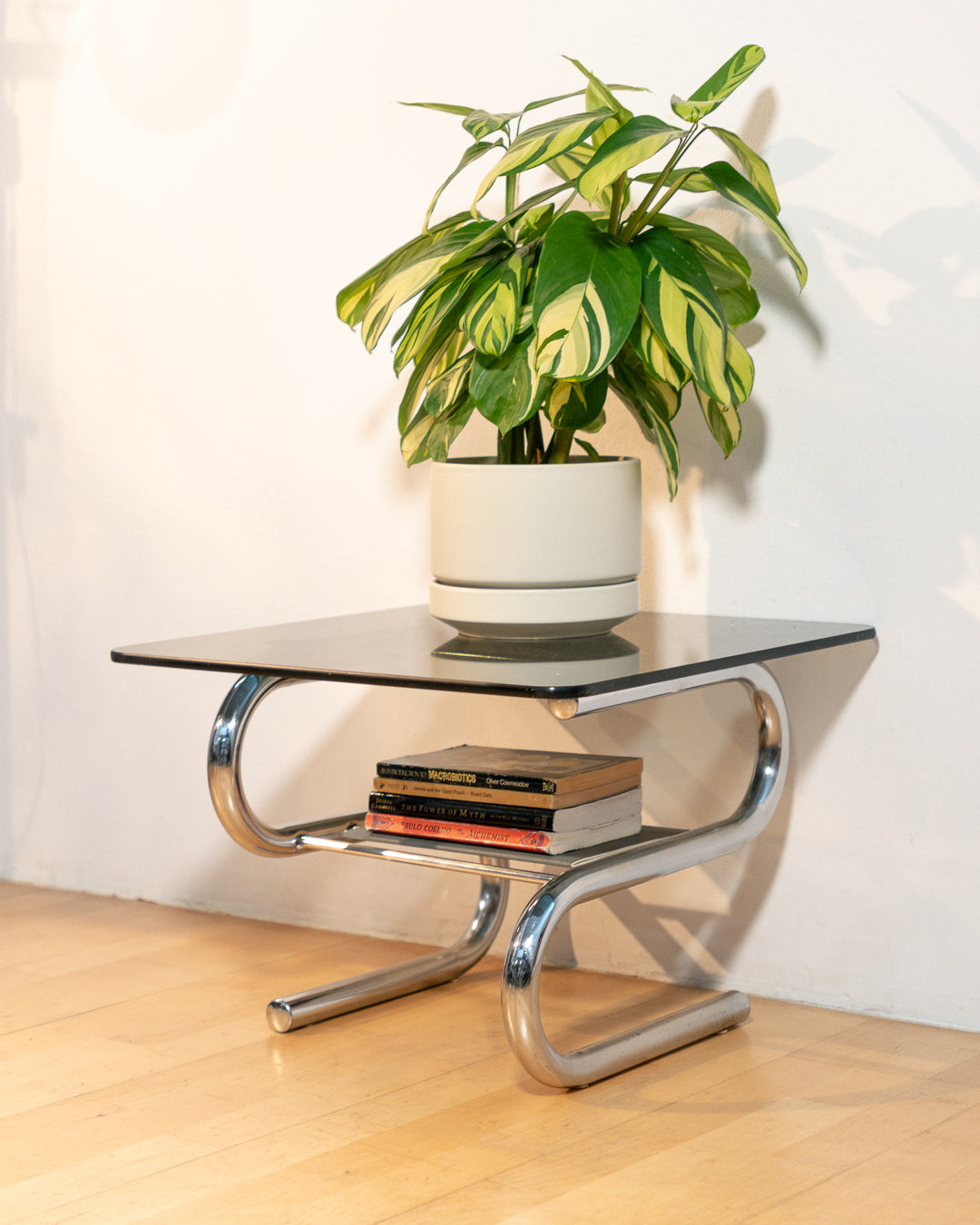 Sculptural 1970s vintage side table with smoked glass top and tubular chrome S-shaped frame with rack. Mid-century design in very good condition.