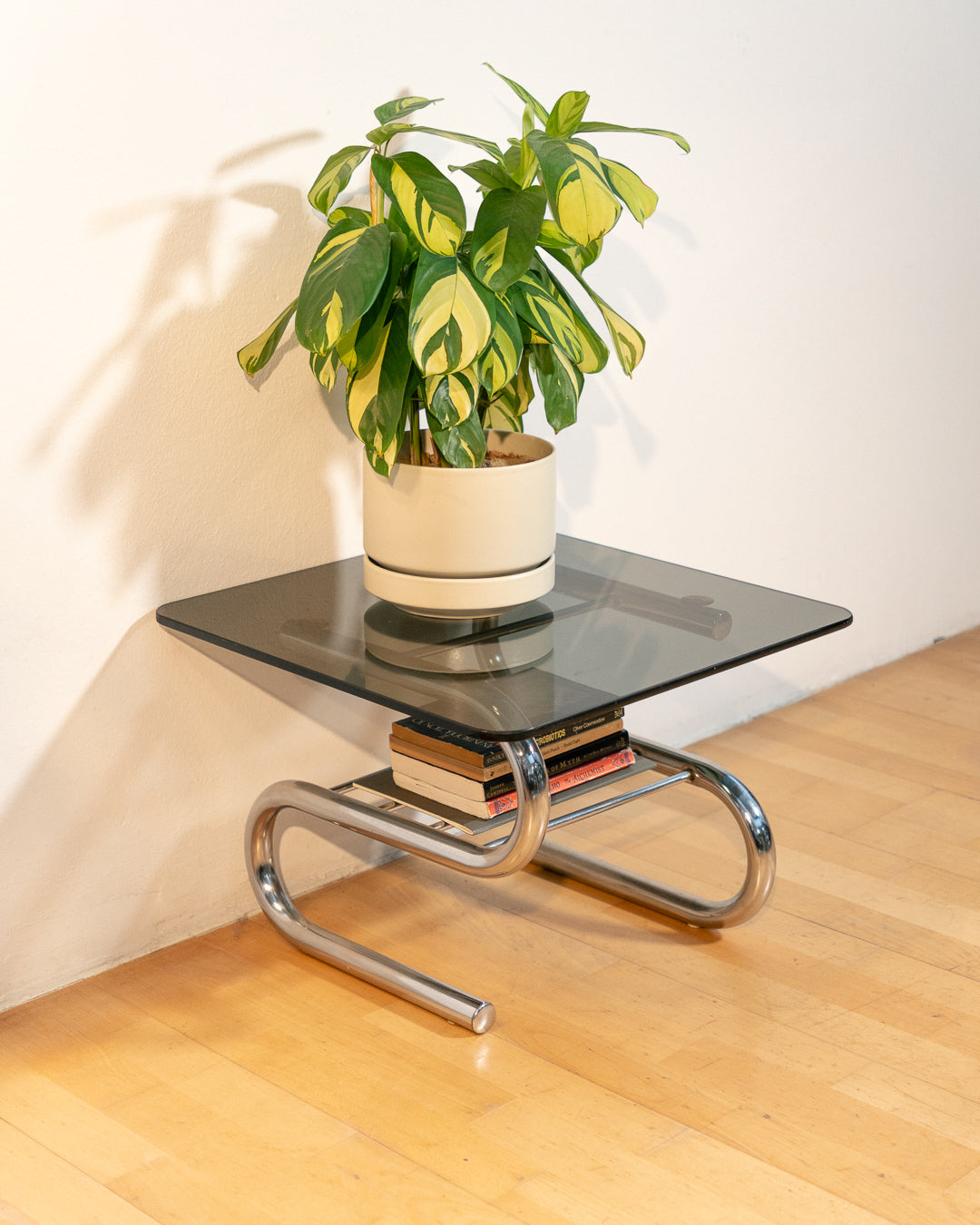 Sculptural 1970s vintage side table with smoked glass top and tubular chrome S-shaped frame with rack. Mid-century design in very good condition.
