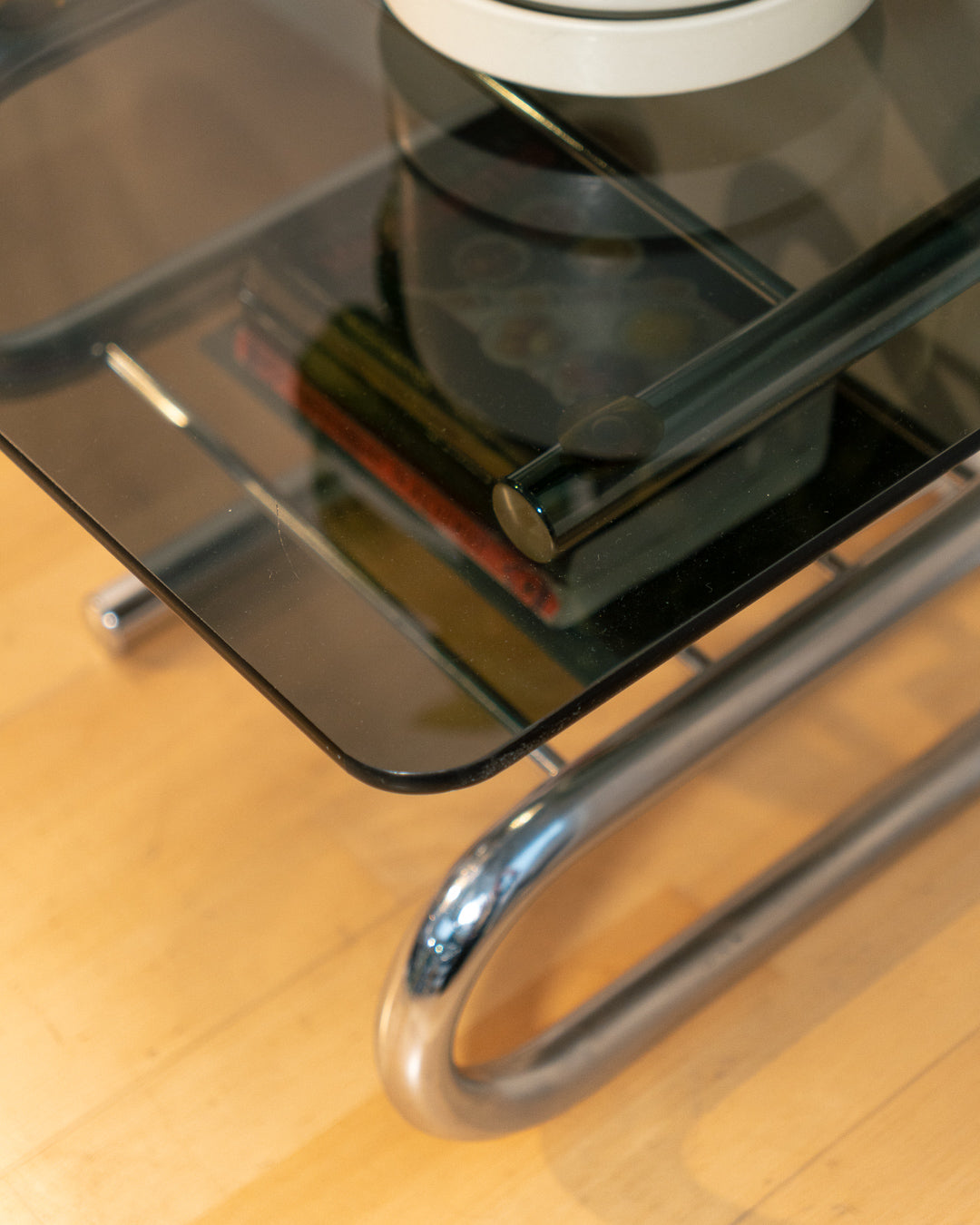 Sculptural 1970s vintage side table with smoked glass top and tubular chrome S-shaped frame with rack. Mid-century design in very good condition.