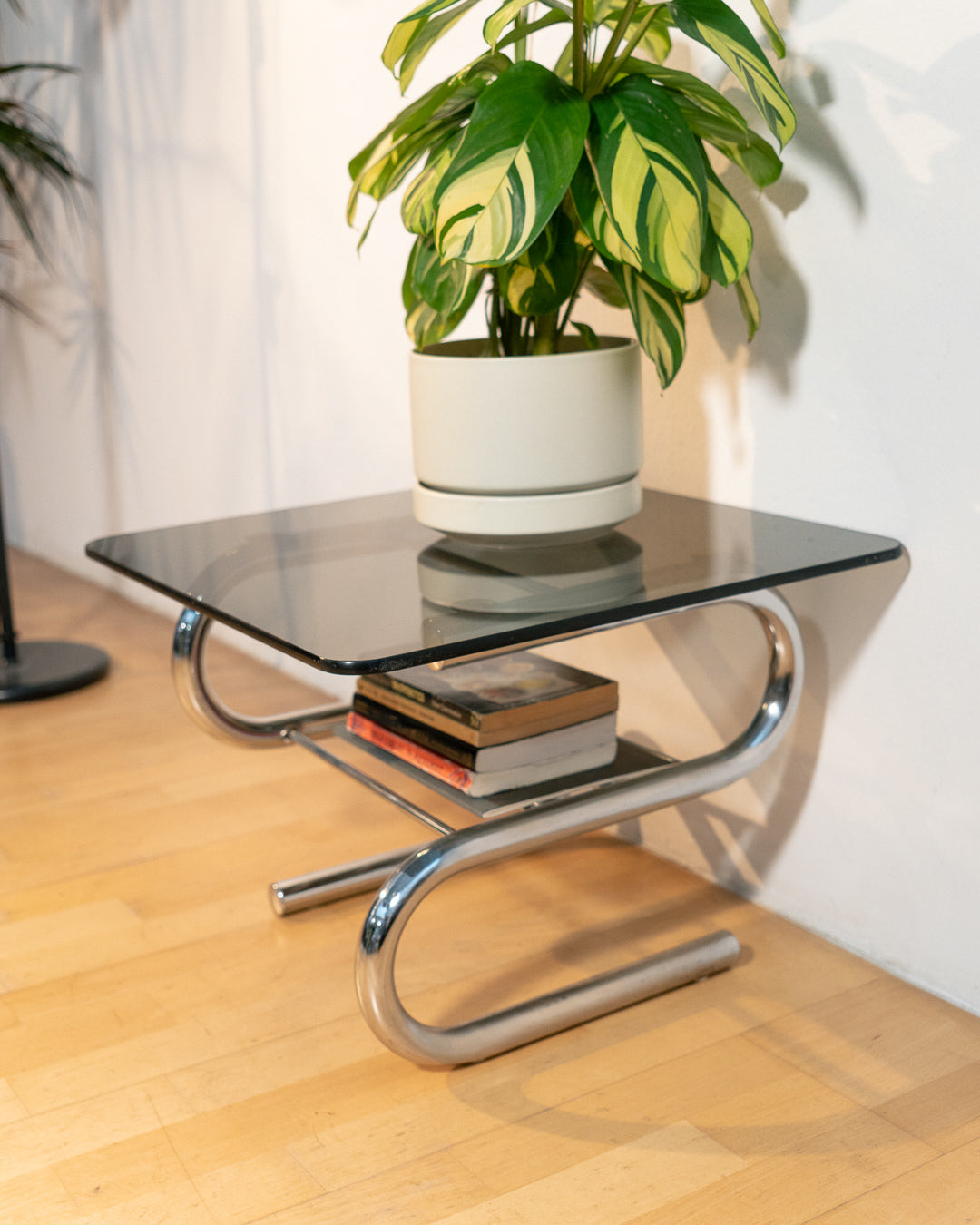 Sculptural 1970s vintage side table with smoked glass top and tubular chrome S-shaped frame with rack. Mid-century design in very good condition.