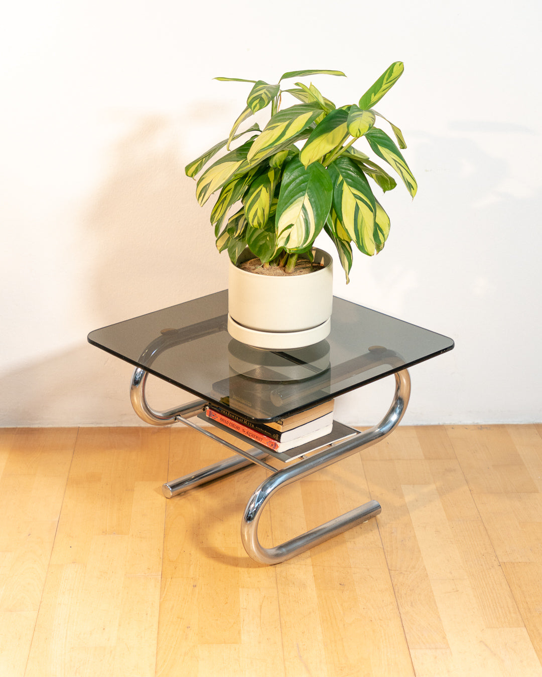 Sculptural 1970s vintage side table with smoked glass top and tubular chrome S-shaped frame with rack. Mid-century design in very good condition.