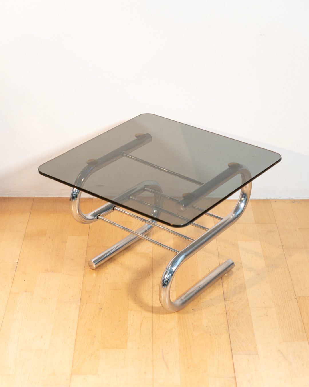 Sculptural 1970s vintage side table with smoked glass top and tubular chrome S-shaped frame with rack. Mid-century design in very good condition.