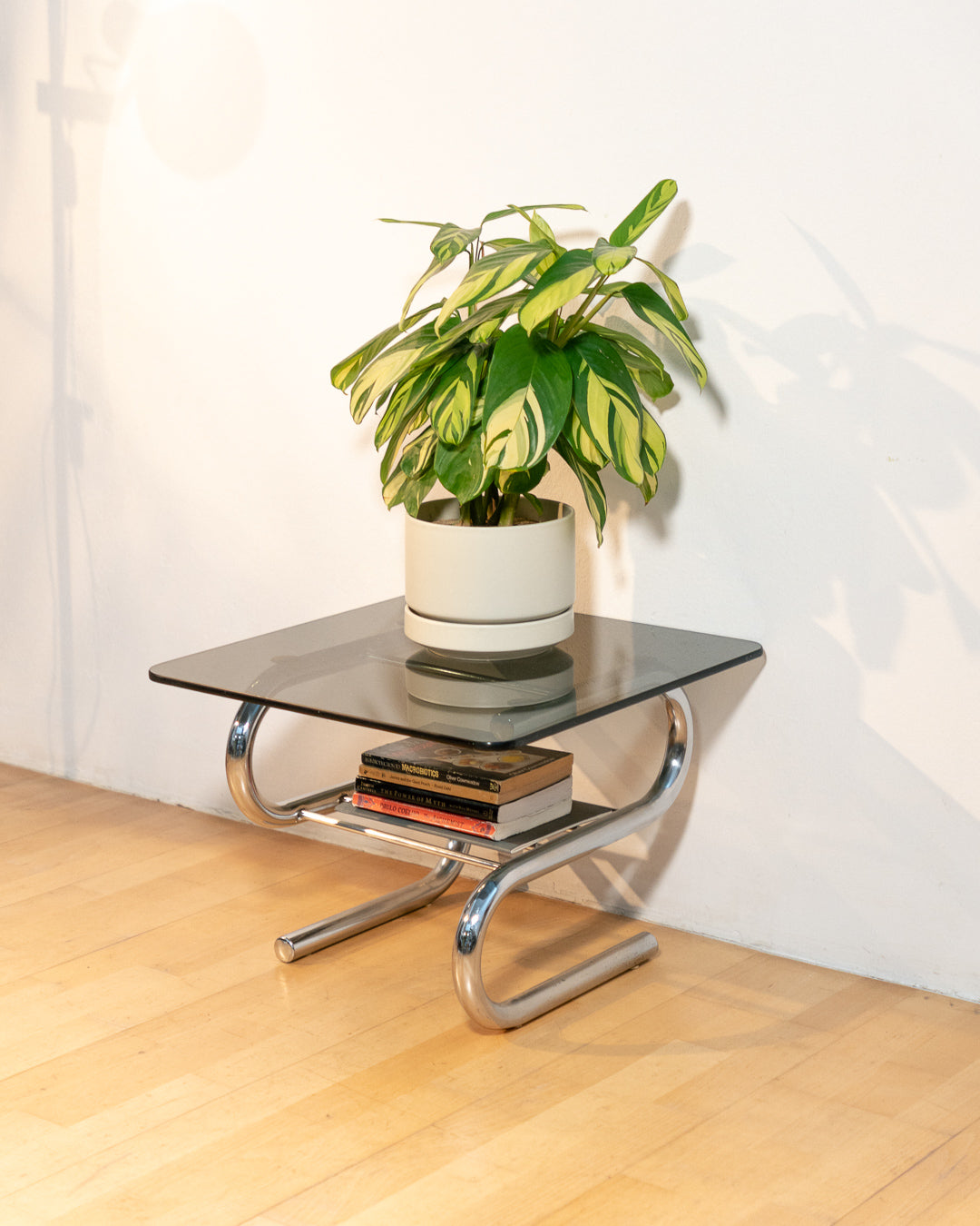 Sculptural 1970s vintage side table with smoked glass top and tubular chrome S-shaped frame with rack. Mid-century design in very good condition.