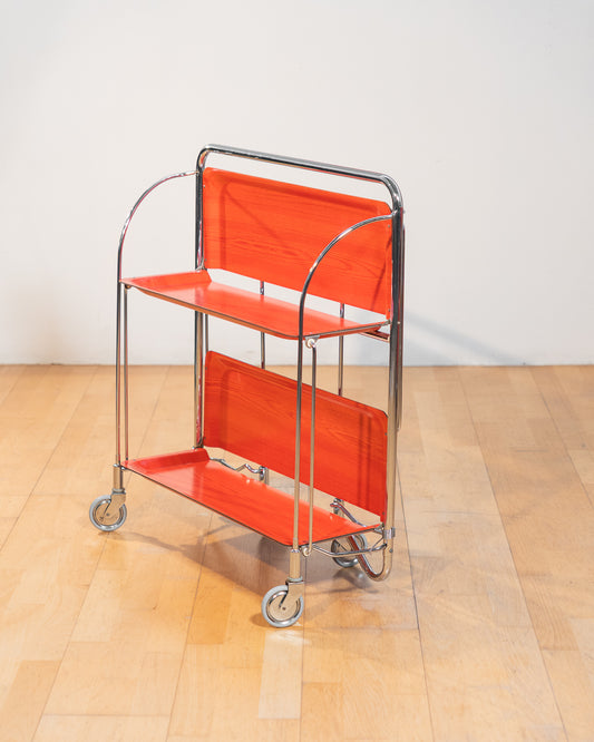Vintage Gerlinol folding serving trolley 1970s, chrome frame with red salmon wood veneer trays, Mid-Century design, compact foldable bar cart with wood grain detail – Vecino Shop