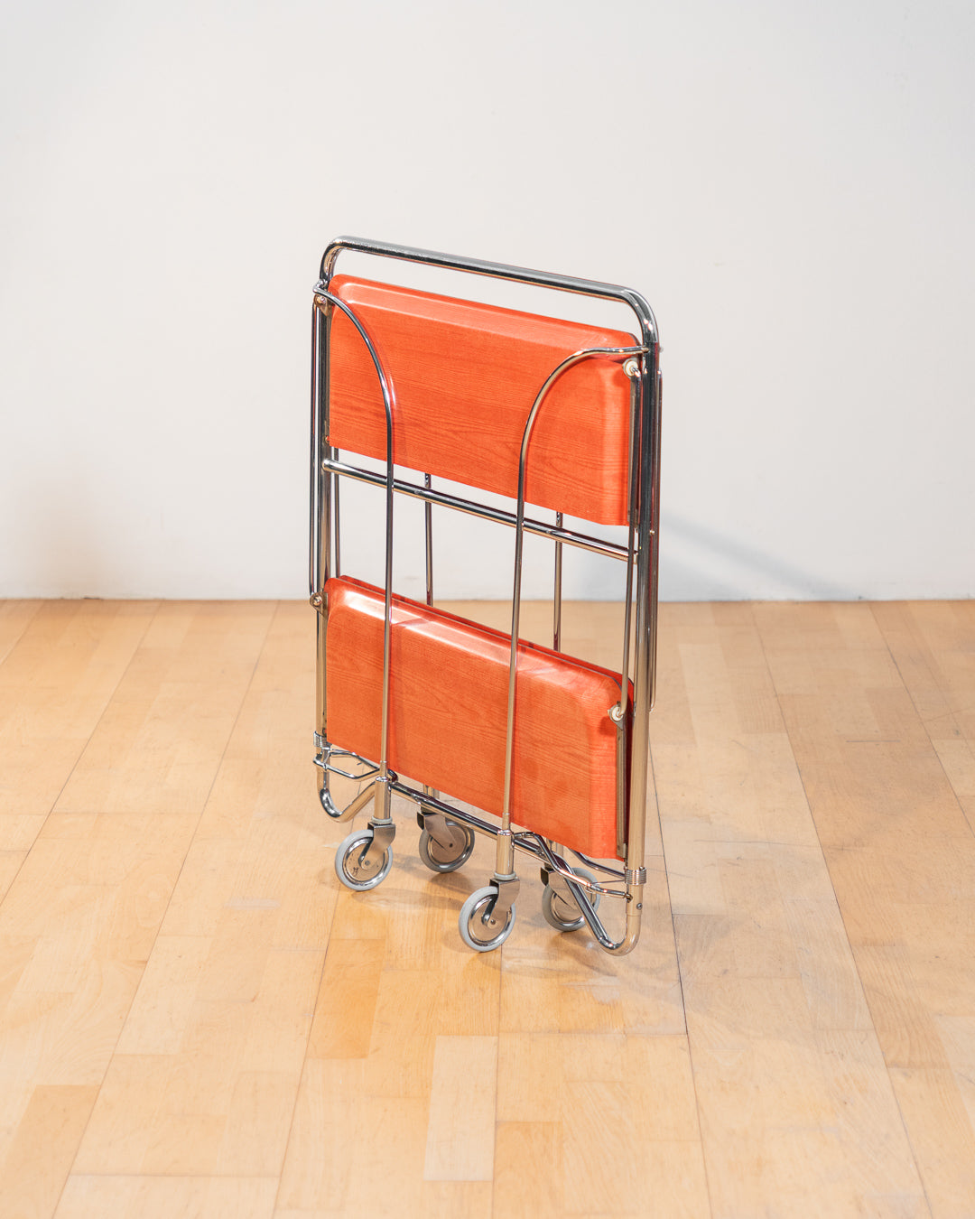 Vintage Gerlinol folding serving trolley 1970s, chrome frame with red salmon wood veneer trays, Mid-Century design, compact foldable bar cart with wood grain detail – Vecino Shop
