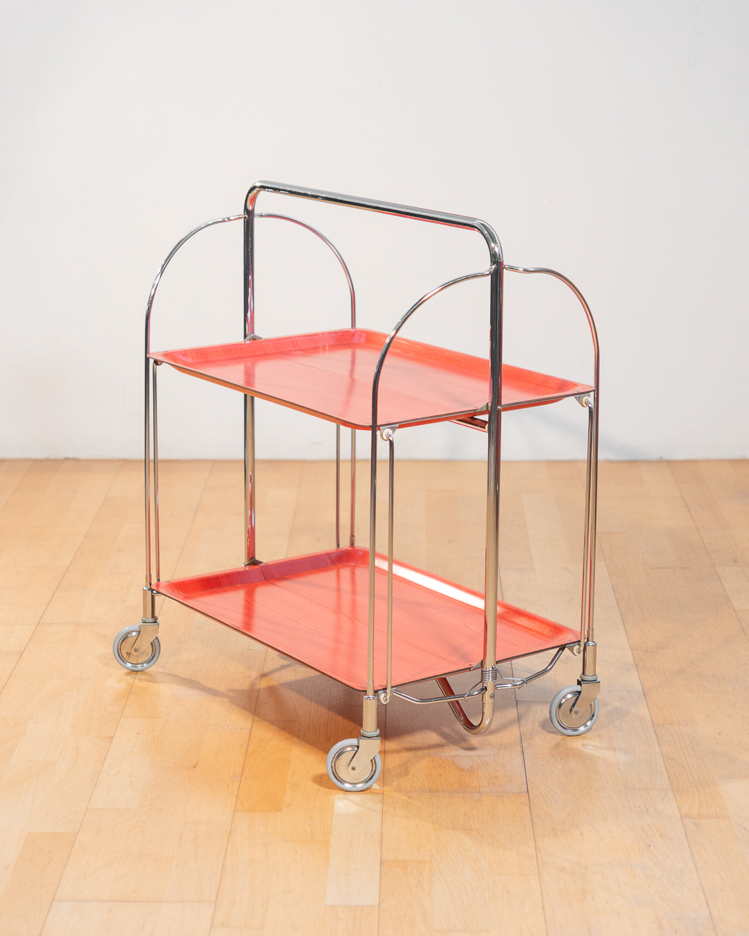 Vintage Gerlinol folding serving trolley 1970s, chrome frame with red salmon wood veneer trays, Mid-Century design, compact foldable bar cart with wood grain detail – Vecino Shop