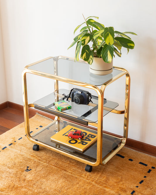 Vintage 1970s gold and smoked glass 3-tier side table, middle sliding shelf, wheels, polished and restored, very good condition | Vecino Shop