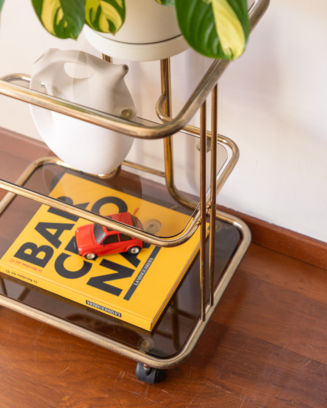 Vintage 1970s gold and smoked glass 3-tier rolling table with worn gold finish