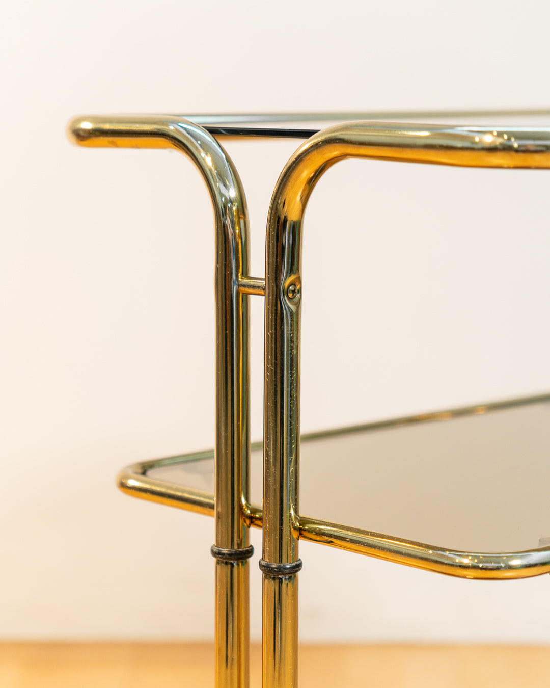 Rare 1970s tubular gold rolling side table with three smoked glass tiers and wheels, vintage Space Age design. Vecino Shop