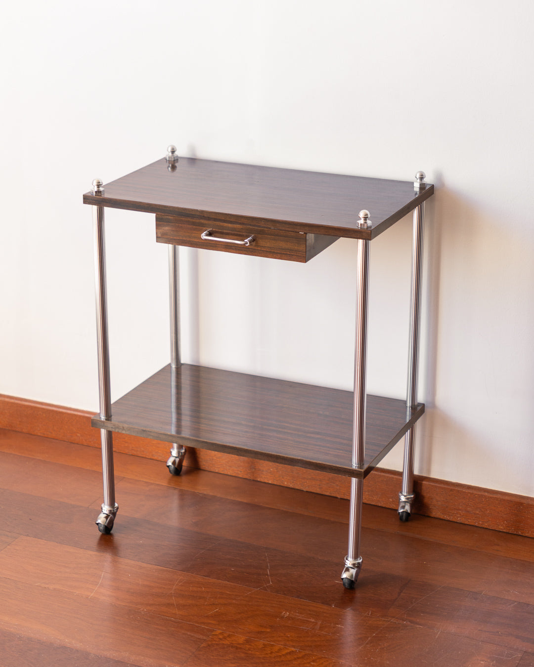 Vintage MCM 1960s chrome and wood veneer rolling table with drawer and caster wheels