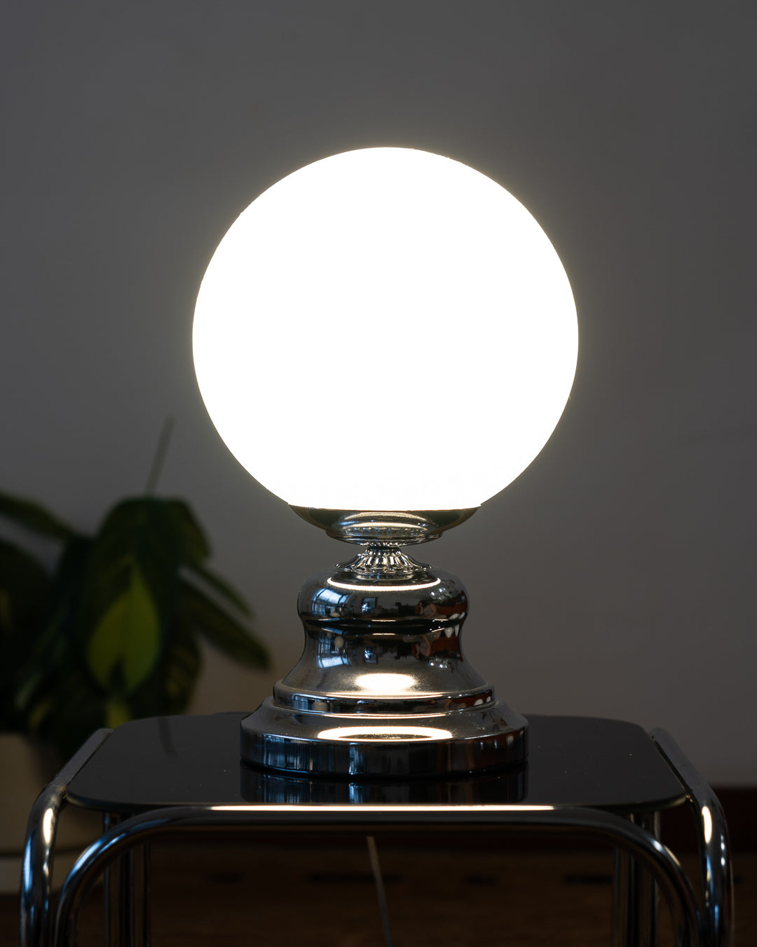 Vintage MCM Chrome Table Lamp with Opaline Globe – Art Deco Design

Striking vintage table lamp featuring a sculptural chrome base and a classic white opaline globe shade. The bold, rounded silhouette of the base brings mid-century atomic flair, while the smooth matte glow of the globe offers timeless softness. A stunning accent light for a console, bedside table, or reading nook