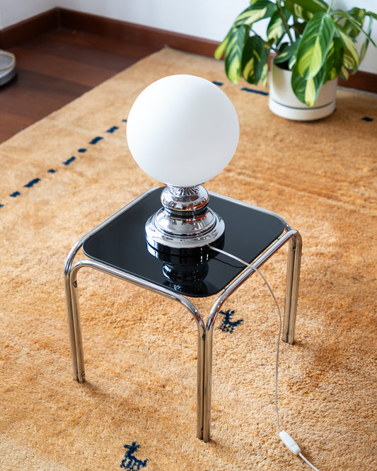 Vintage MCM Chrome Table Lamp with Opaline Globe – Art Deco Design

Striking vintage table lamp featuring a sculptural chrome base and a classic white opaline globe shade. The bold, rounded silhouette of the base brings mid-century atomic flair, while the smooth matte glow of the globe offers timeless softness. A stunning accent light for a console, bedside table, or reading nook
