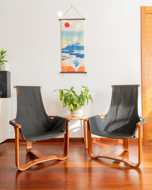 Pair of Manta-style lounge chairs with wooden frames and worn upholstery, shown as a restoration project.