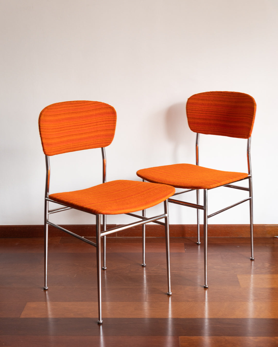 Pair of 1960s Space Age chrome chairs with orange striped fabric upholstery.