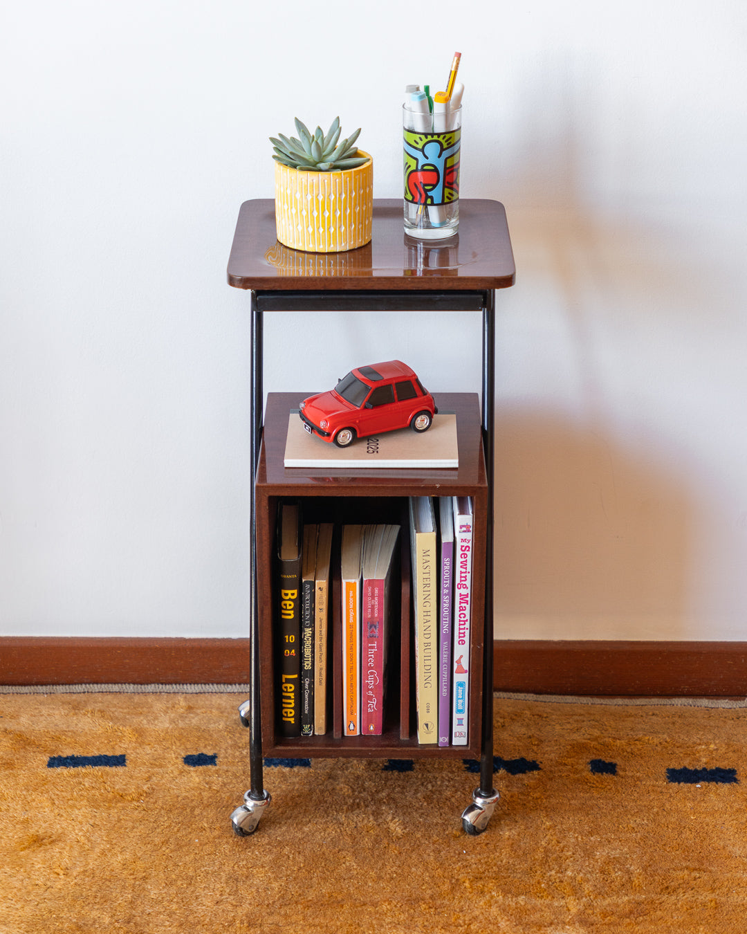 Vintage 1960s wooden rolling side table with black metal frame, magazine rack – Vecino Shop