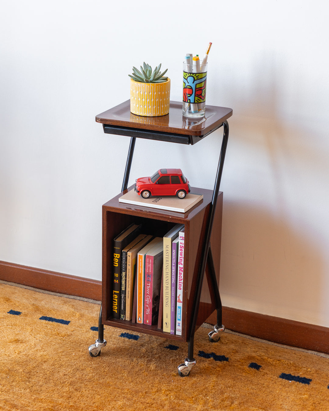 Vintage 1960s wooden rolling side table with black metal frame, magazine rack – Vecino Shop