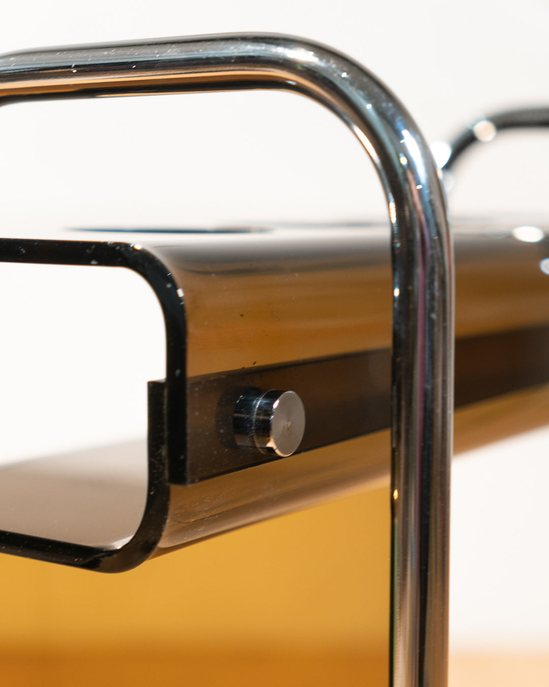 1970s smoked amber acrylic bar cart with chrome handles and casters, sculptural U-shaped design