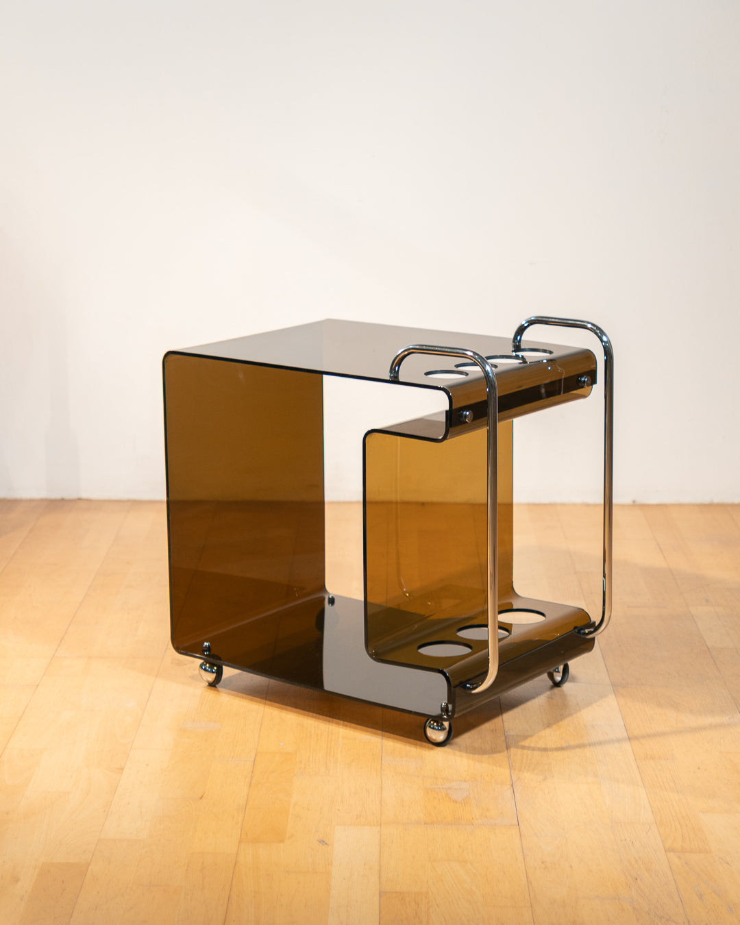 1970s smoked amber acrylic bar cart with chrome handles and casters, sculptural U-shaped design