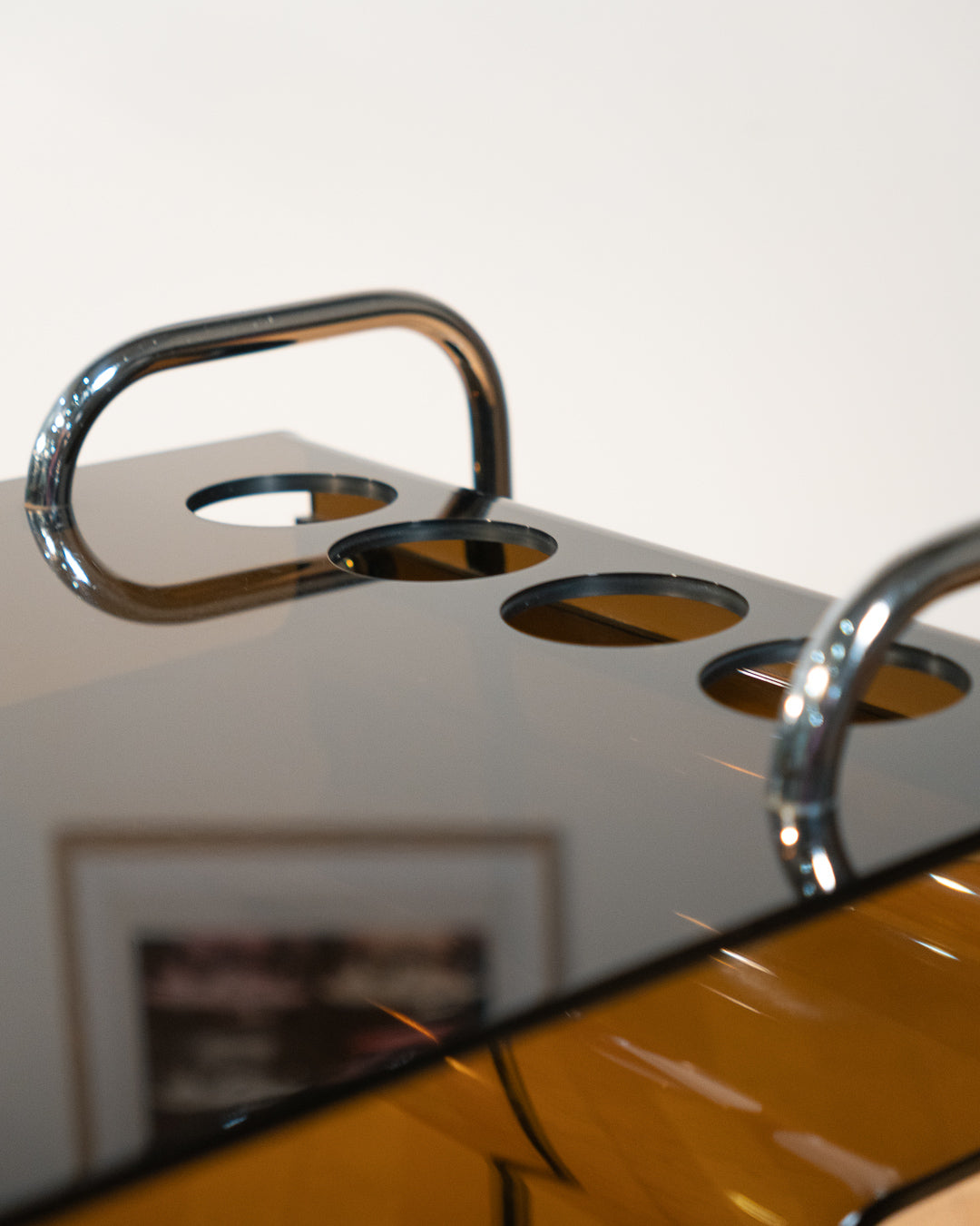 1970s smoked amber acrylic bar cart with chrome handles and casters, sculptural U-shaped design