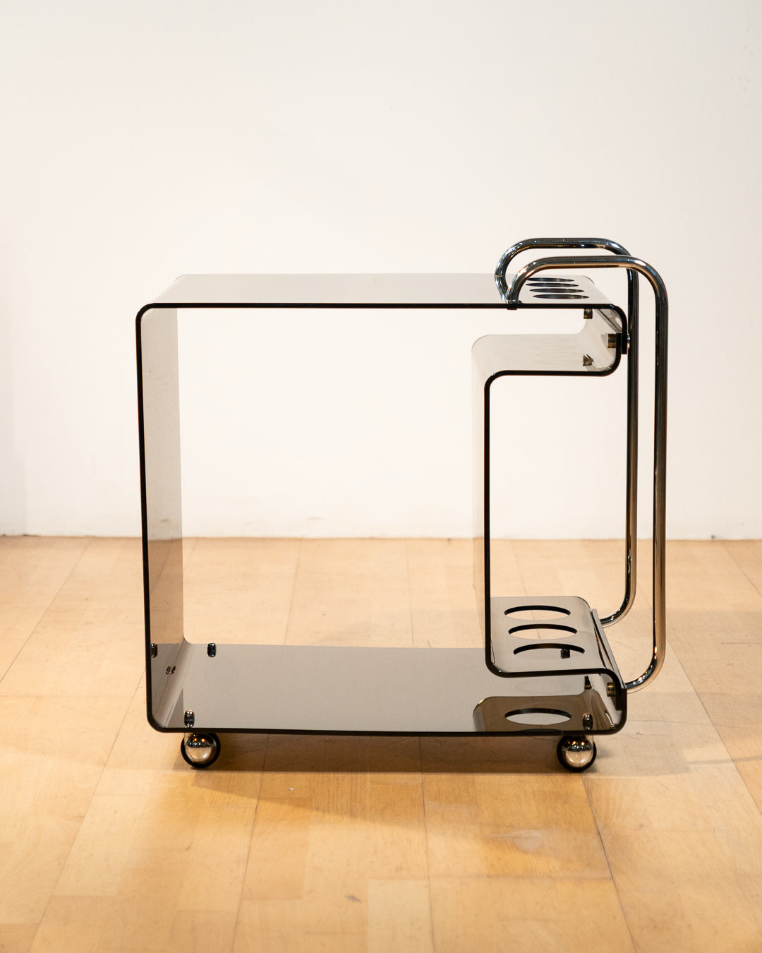 1970s smoked amber acrylic bar cart with chrome handles and casters, sculptural U-shaped design