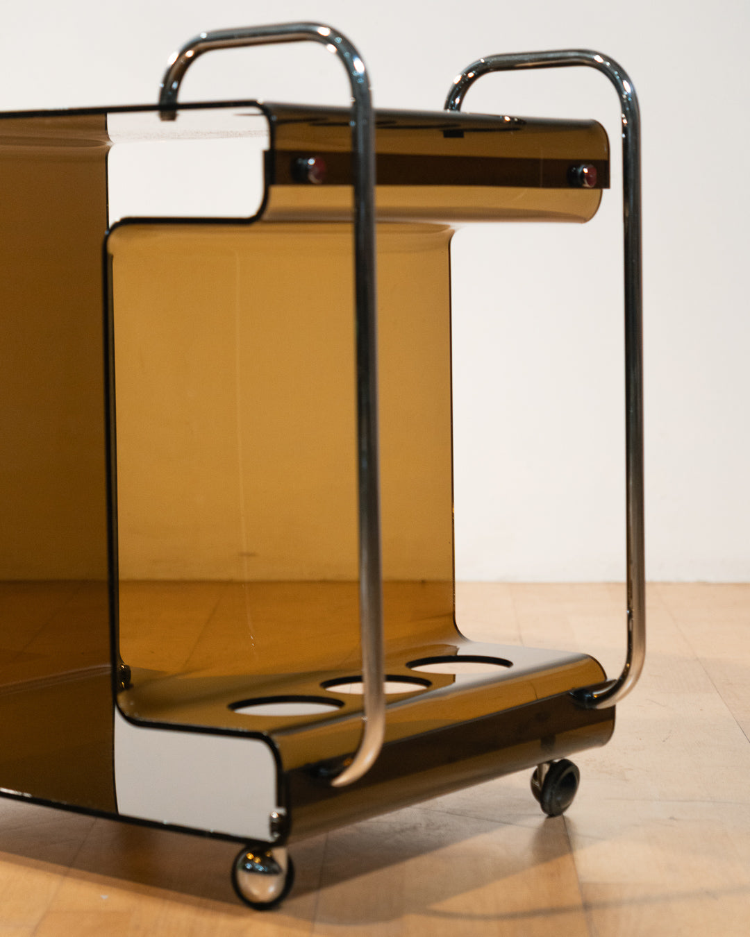 1970s smoked amber acrylic bar cart with chrome handles and casters, sculptural U-shaped design
