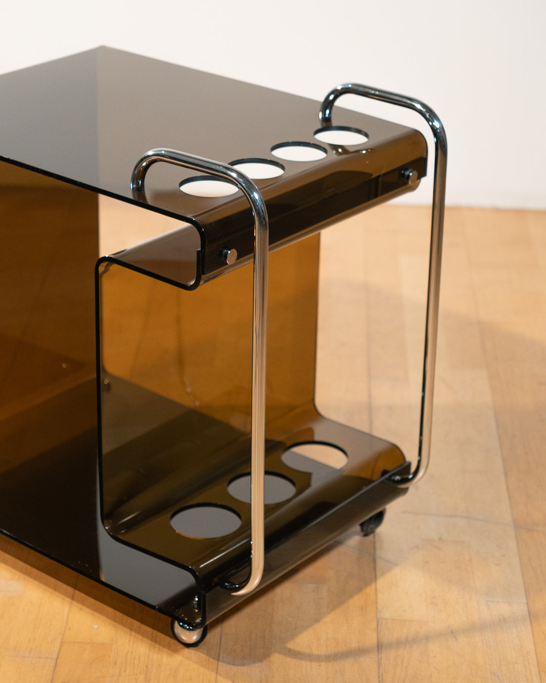 1970s smoked amber acrylic bar cart with chrome handles and casters, sculptural U-shaped design