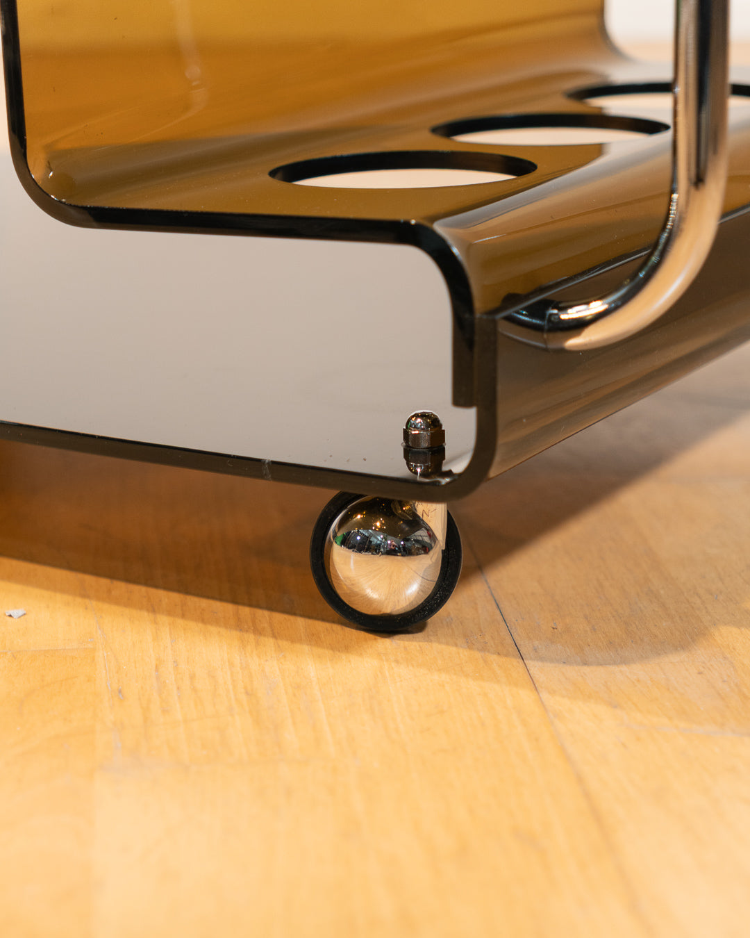 1970s smoked amber acrylic bar cart with chrome handles and casters, sculptural U-shaped design