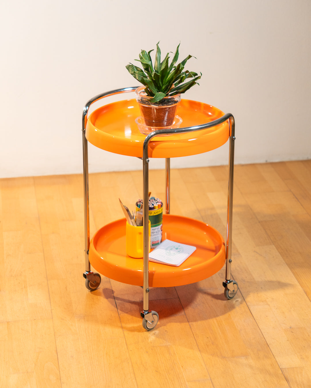 Rare 1970s round chrome bar cart with orange shelves, two tier design, restored vintage trolley with signs of use. Vecino Shop
