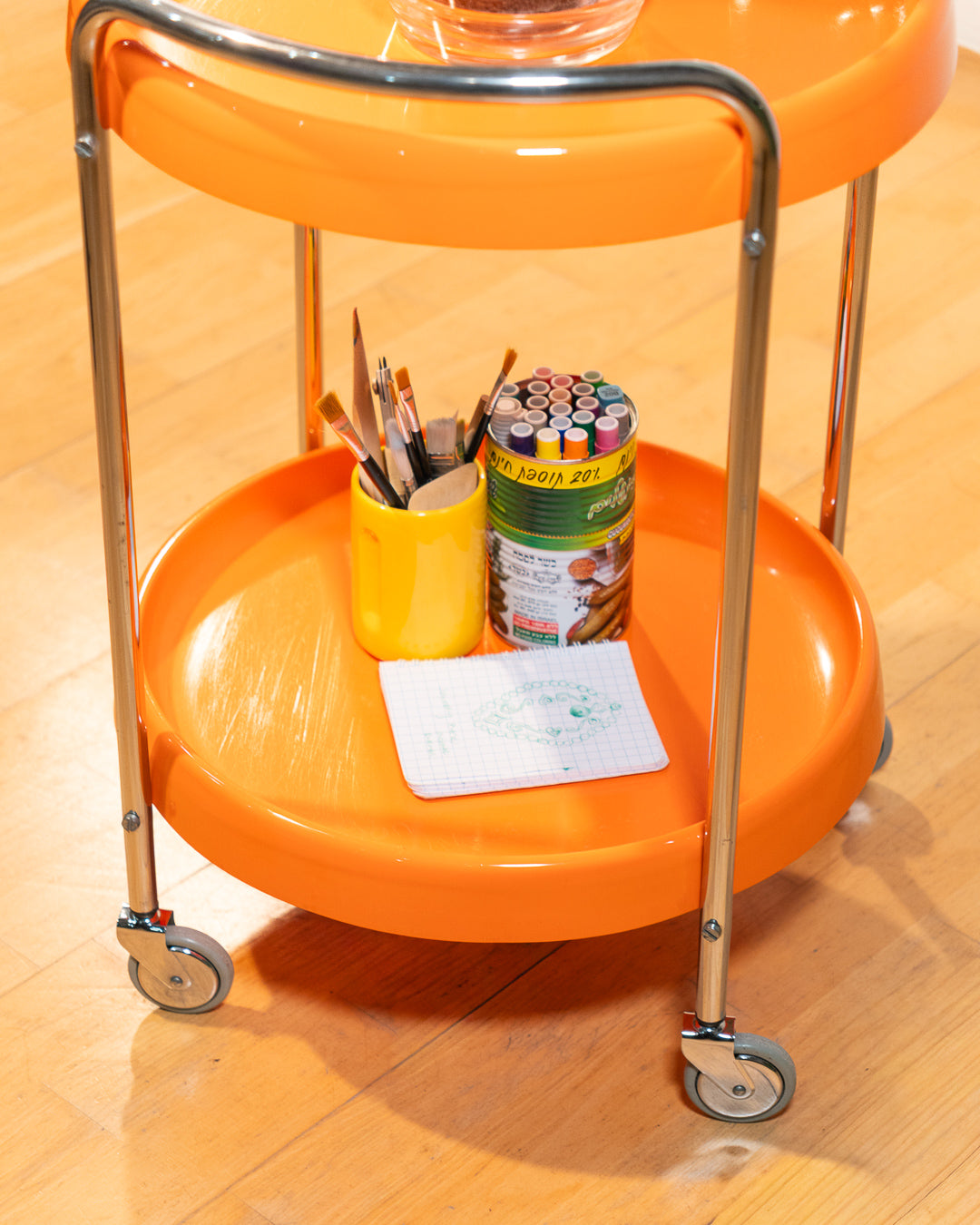 Rare 1970s round chrome bar cart with orange shelves, two tier design, restored vintage trolley with signs of use. Vecino Shop