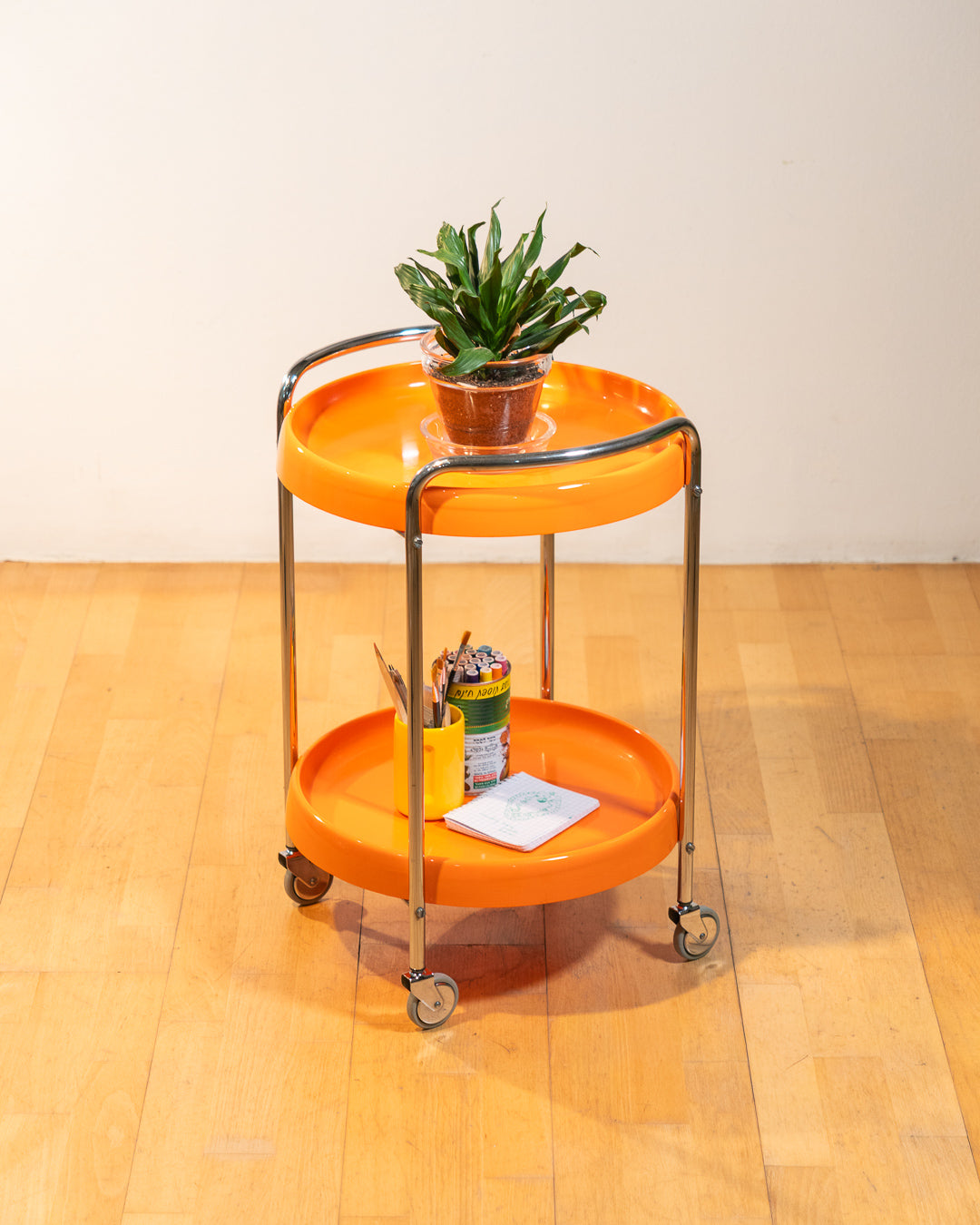 Rare 1970s round chrome bar cart with orange shelves, two tier design, restored vintage trolley with signs of use. Vecino Shop
