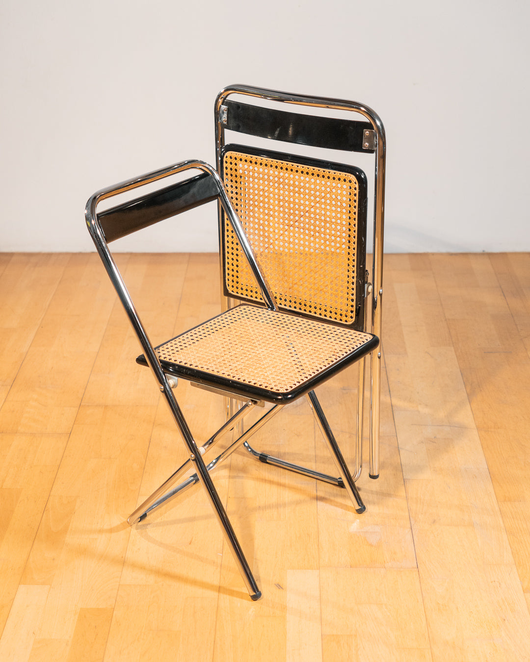 Vintage 1970s foldable rattan chair with chrome frame and lacquered wood backrest, iconic retro design, in very good vintage condition. Vecino Shop