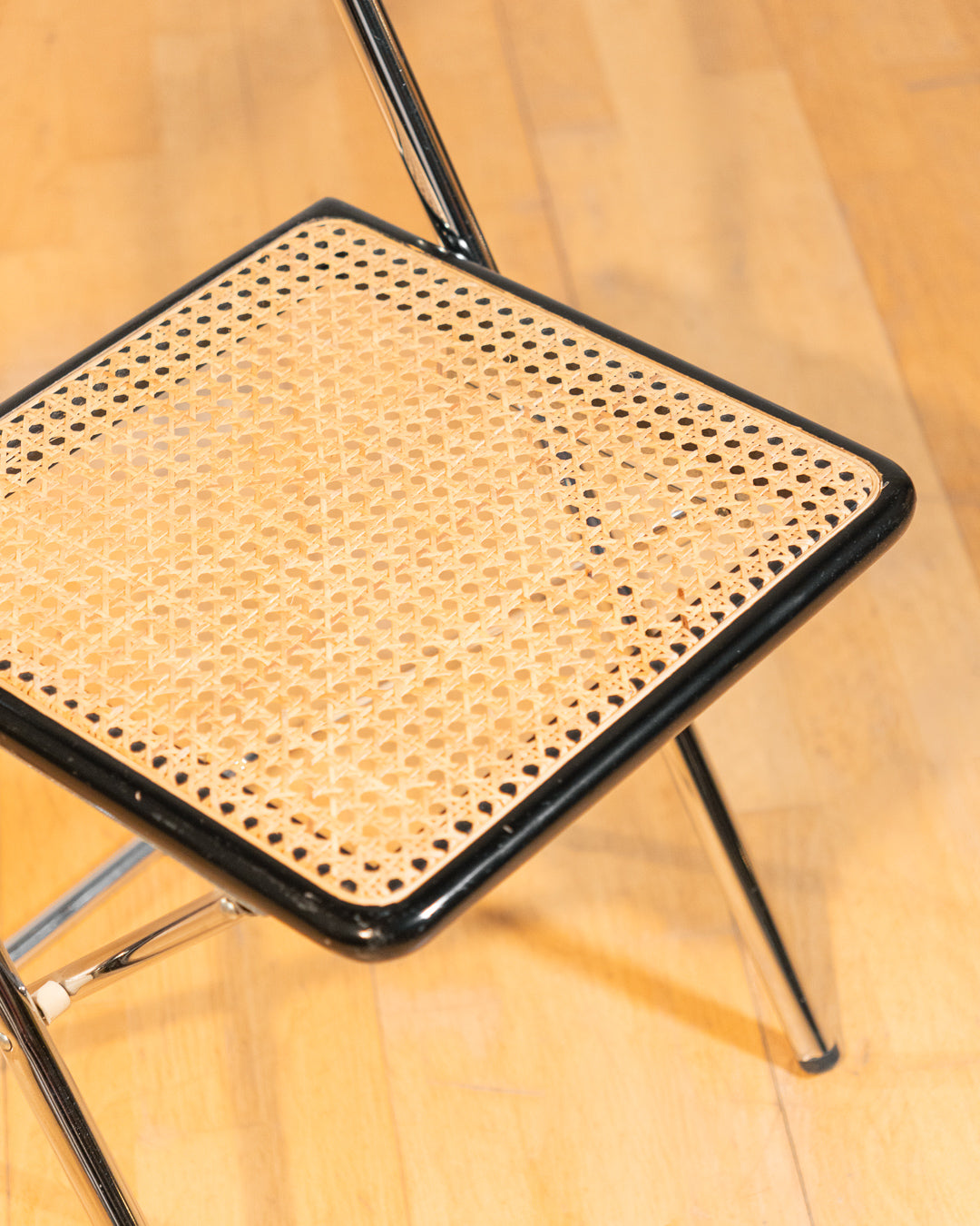 Vintage 1970s foldable rattan chair with chrome frame and lacquered wood backrest, iconic retro design, in very good vintage condition. Vecino Shop